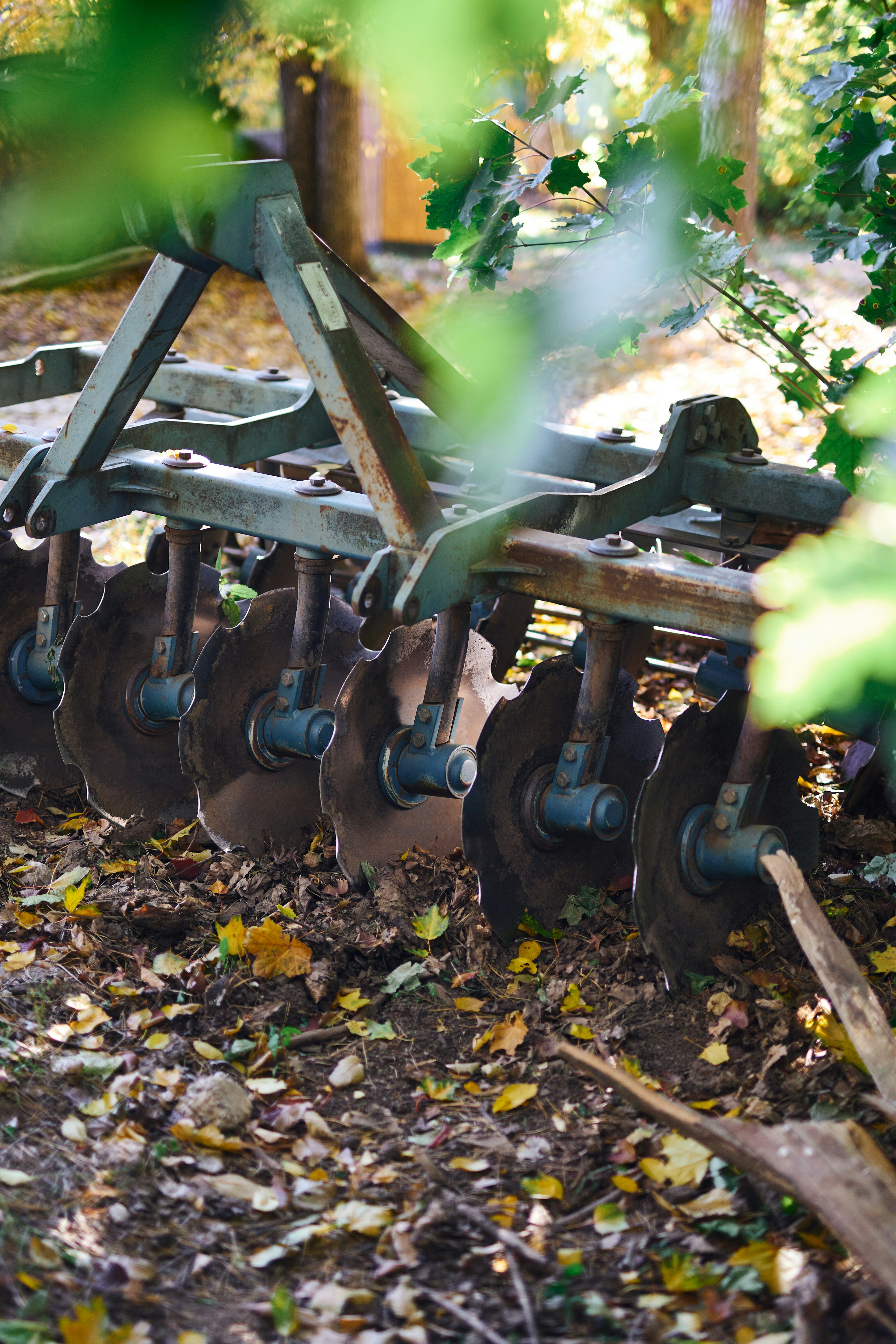 A row of metal plows sitting on top of a field