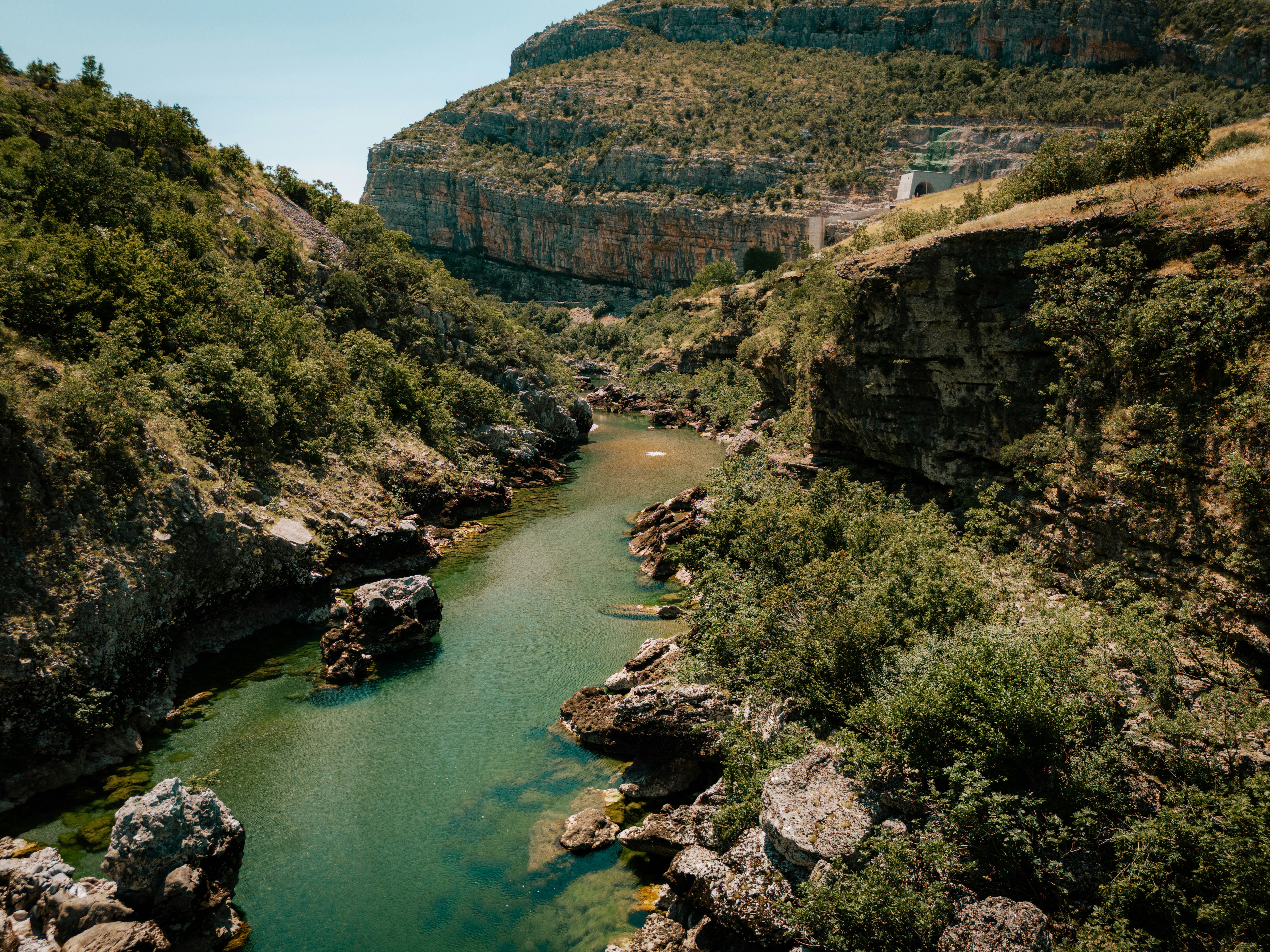 Um rio correndo por um vale verdejante