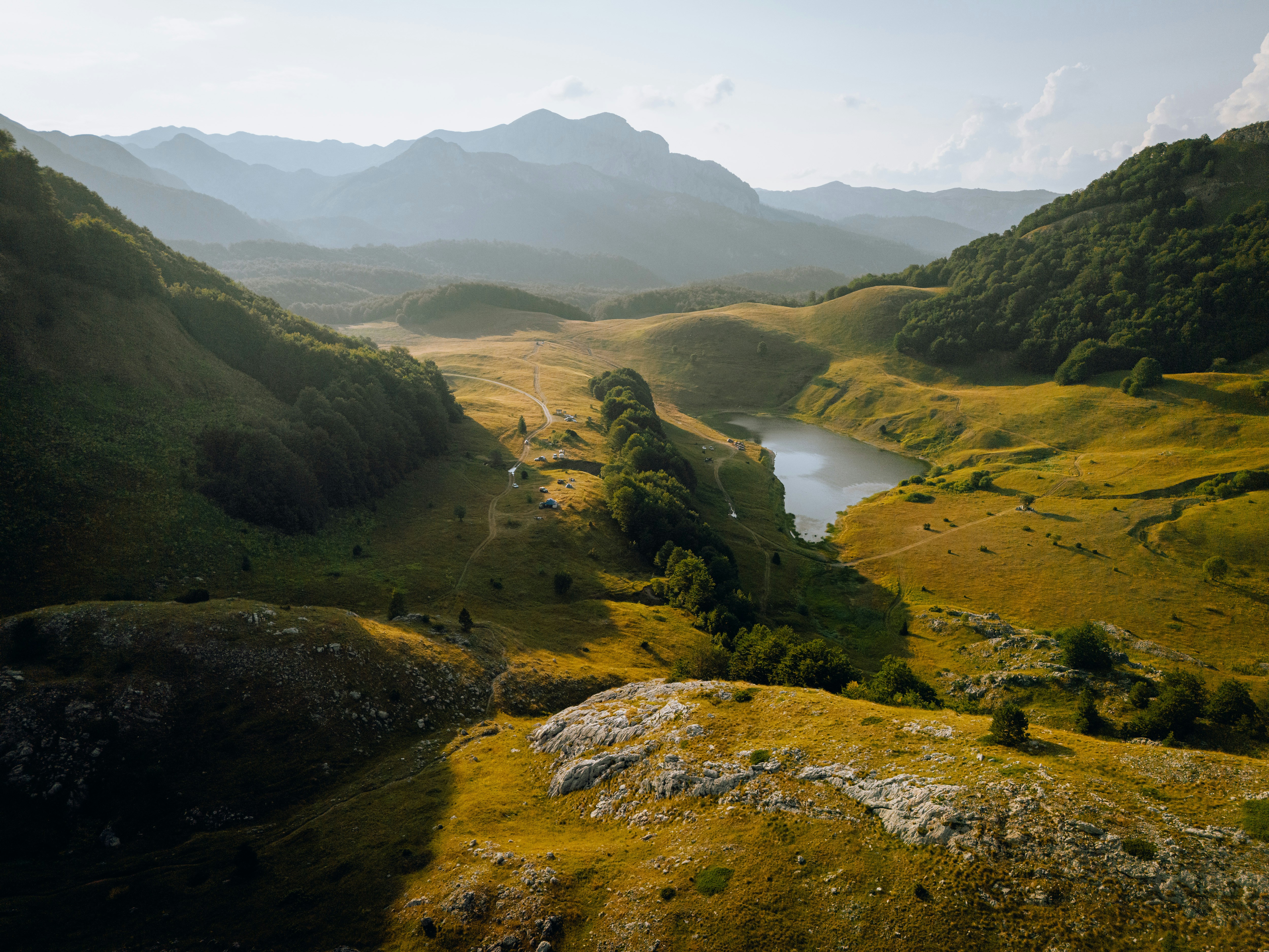 Uma vista de um vale com montanhas ao fundo