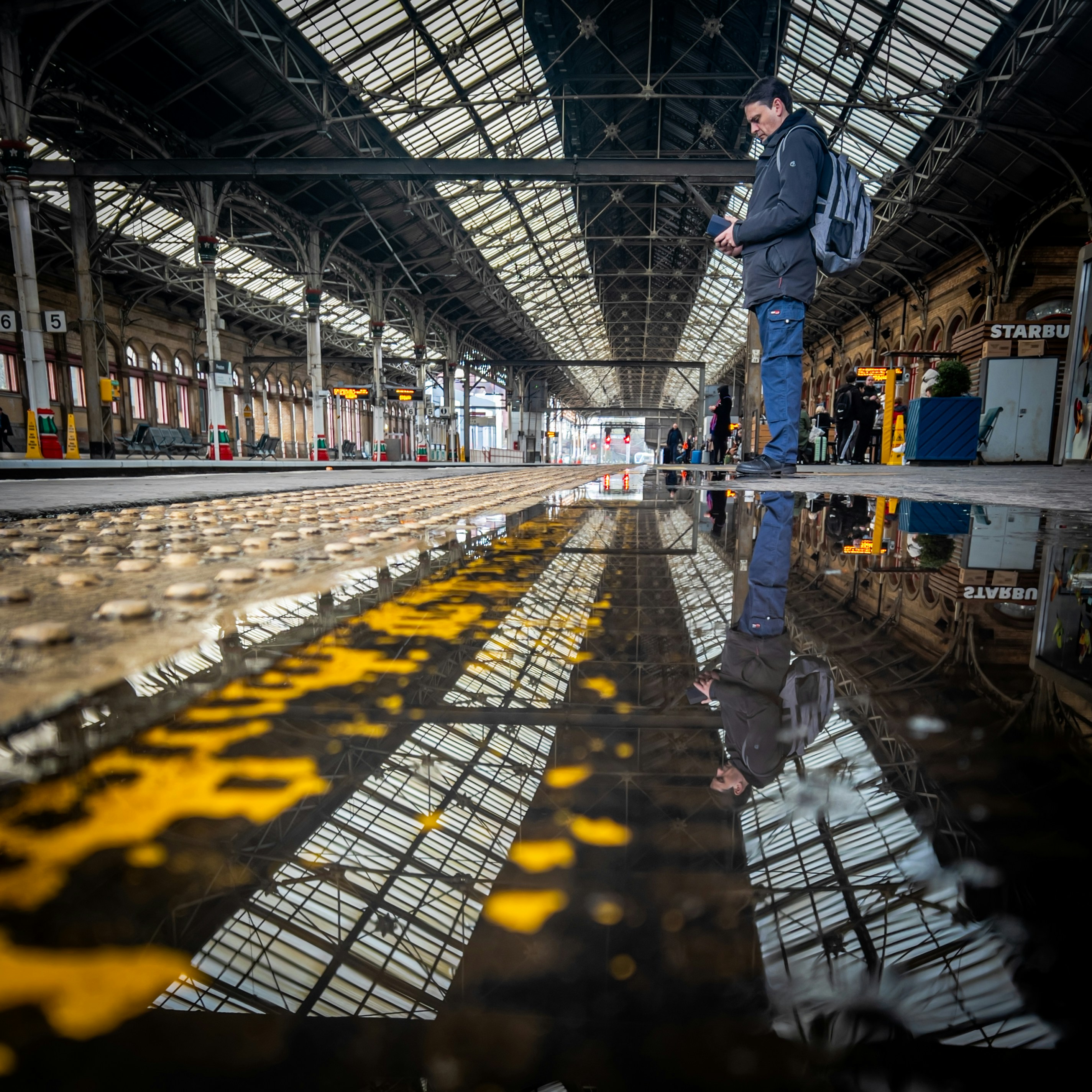 A man is standing in a train station