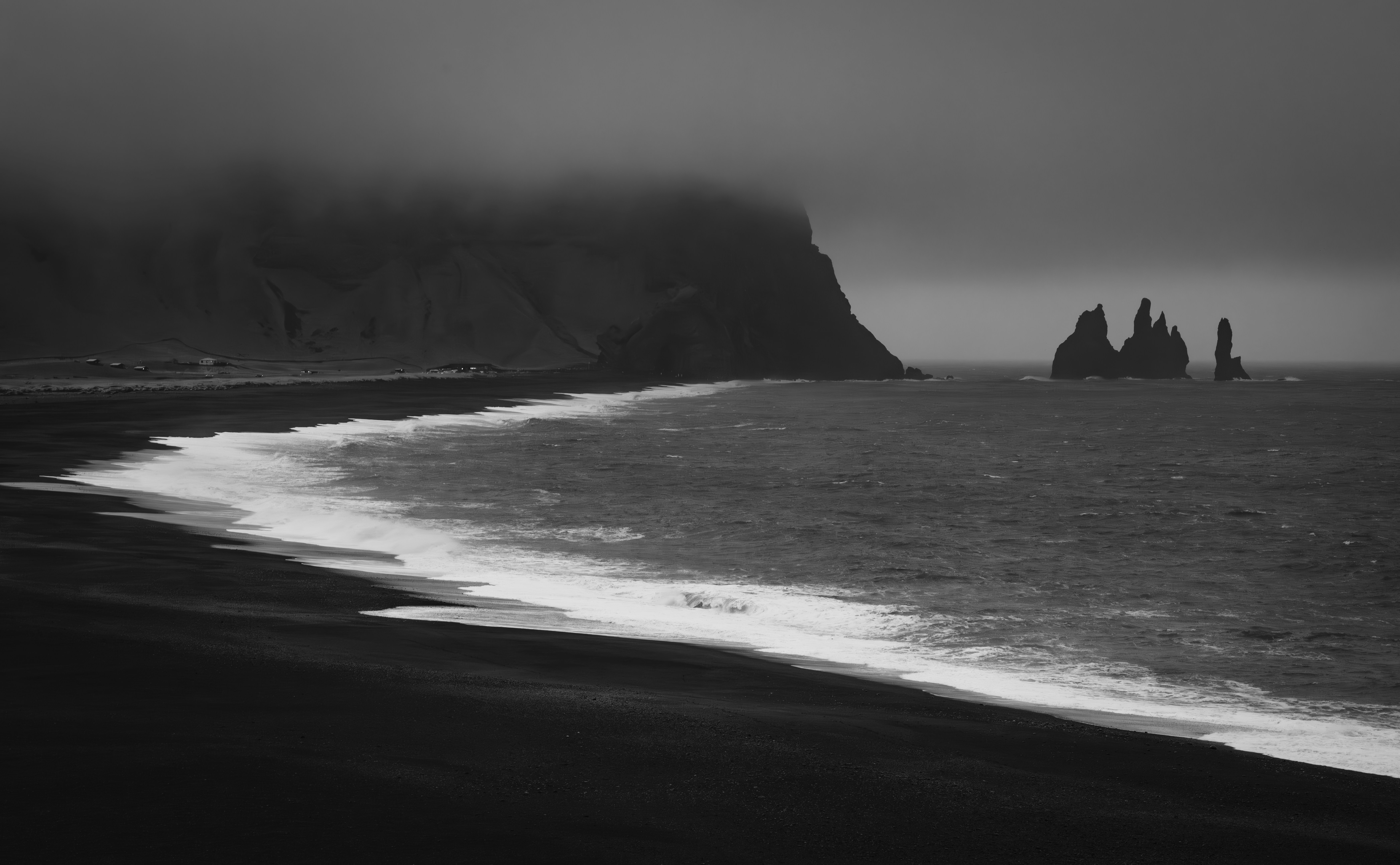 A black and white photo of a beach and cliffs