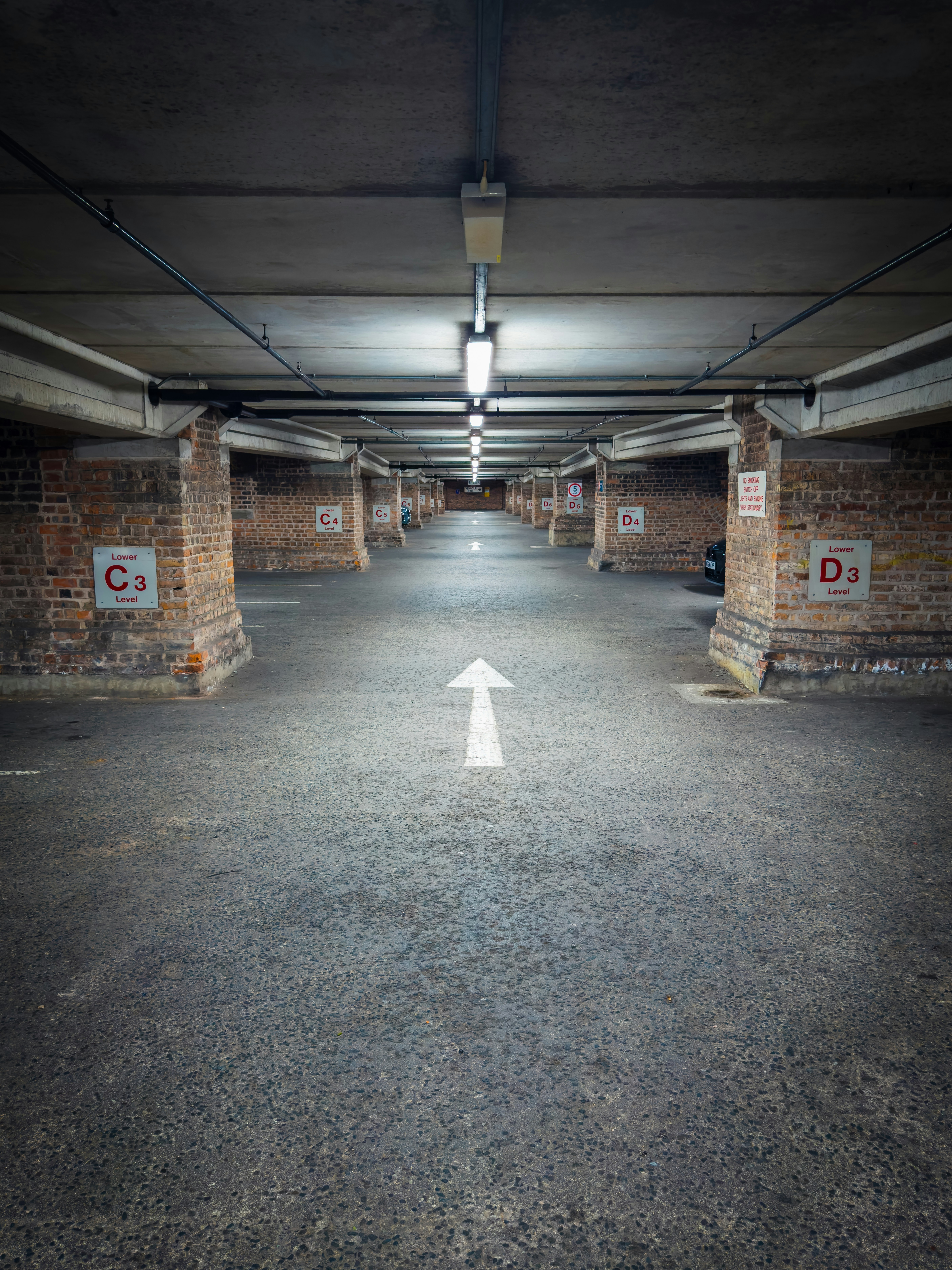 An empty parking garage with a white arrow pointing to the left