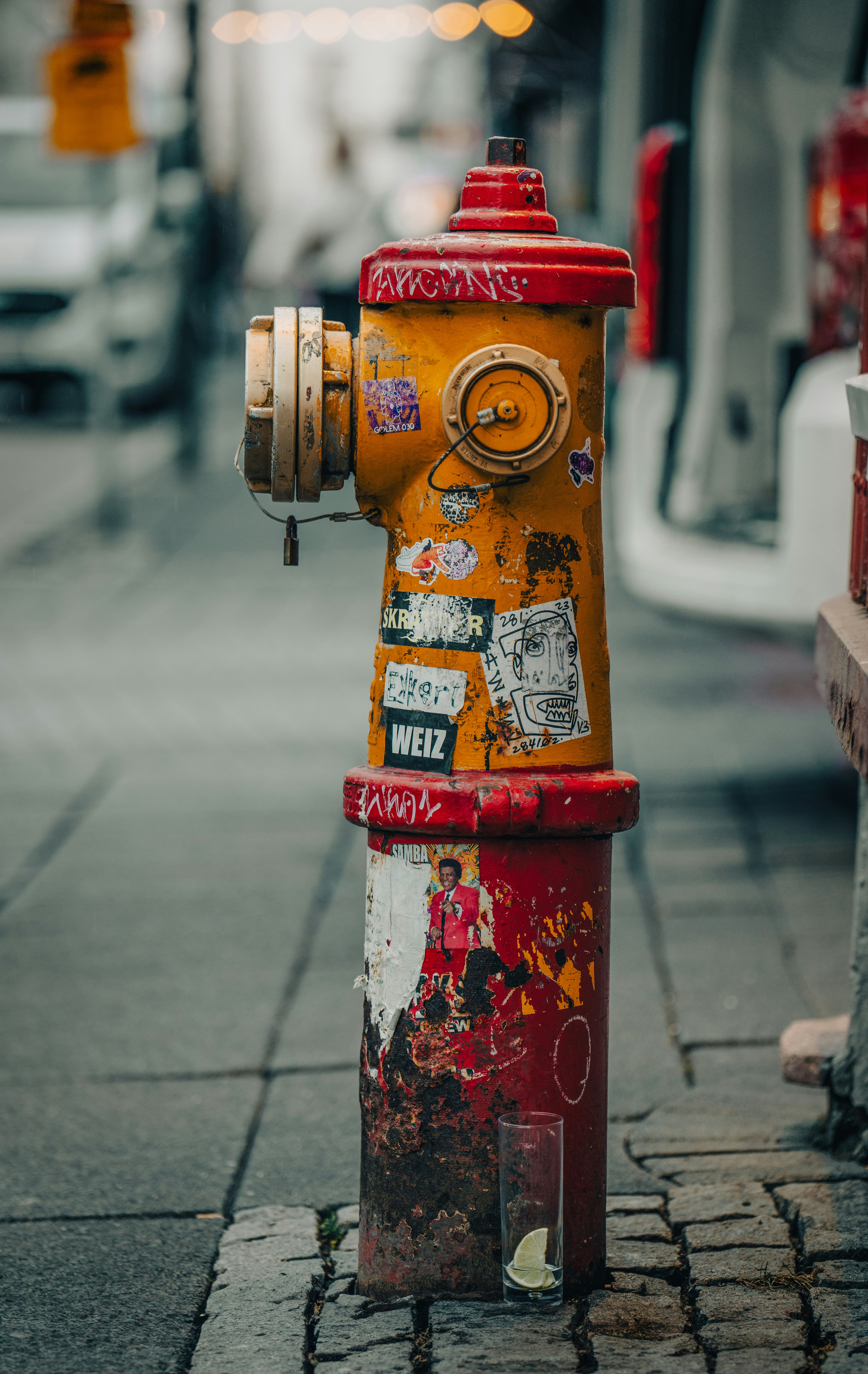 A yellow and red fire hydrant sitting on the side of a road