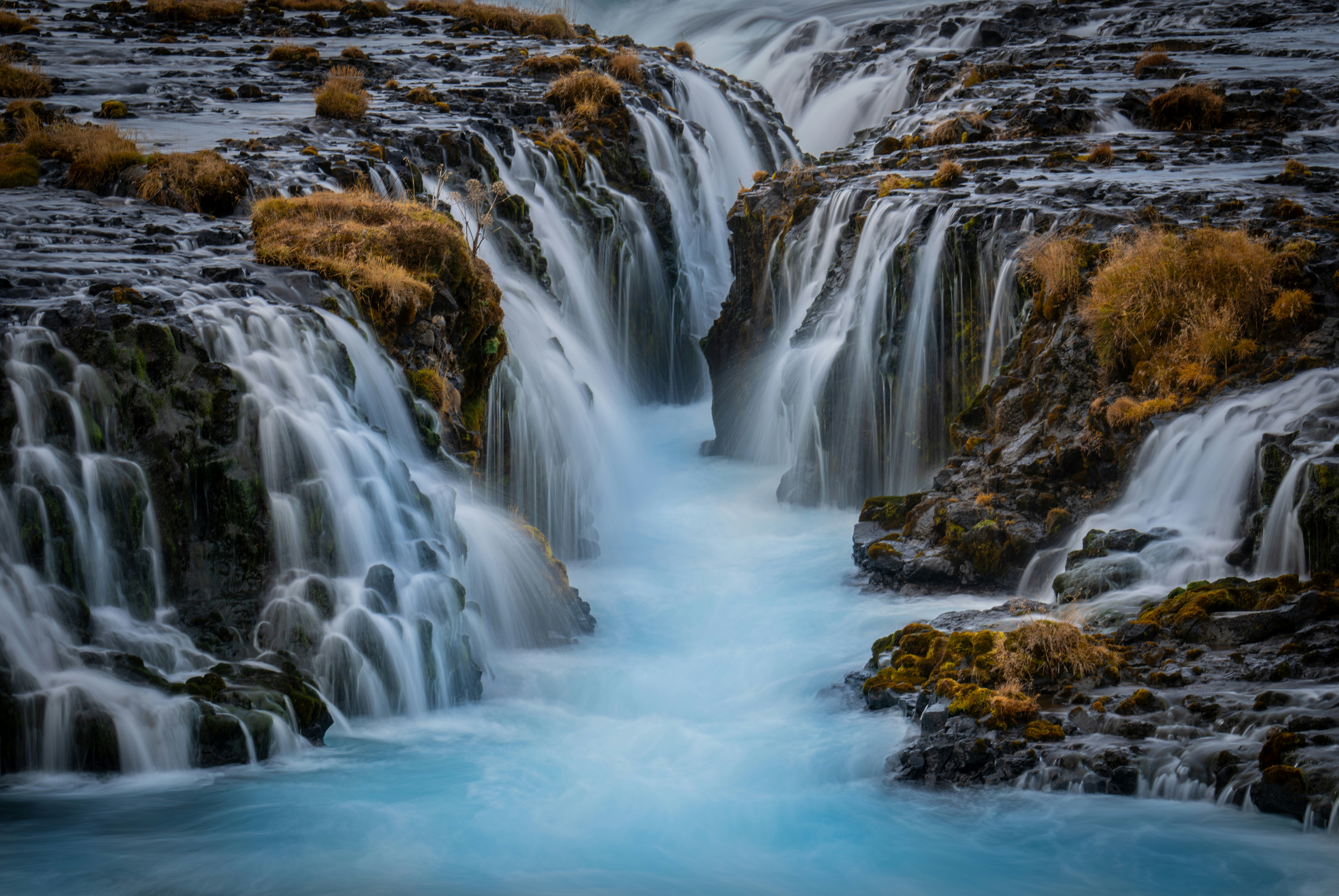 A waterfall with blue water running down it