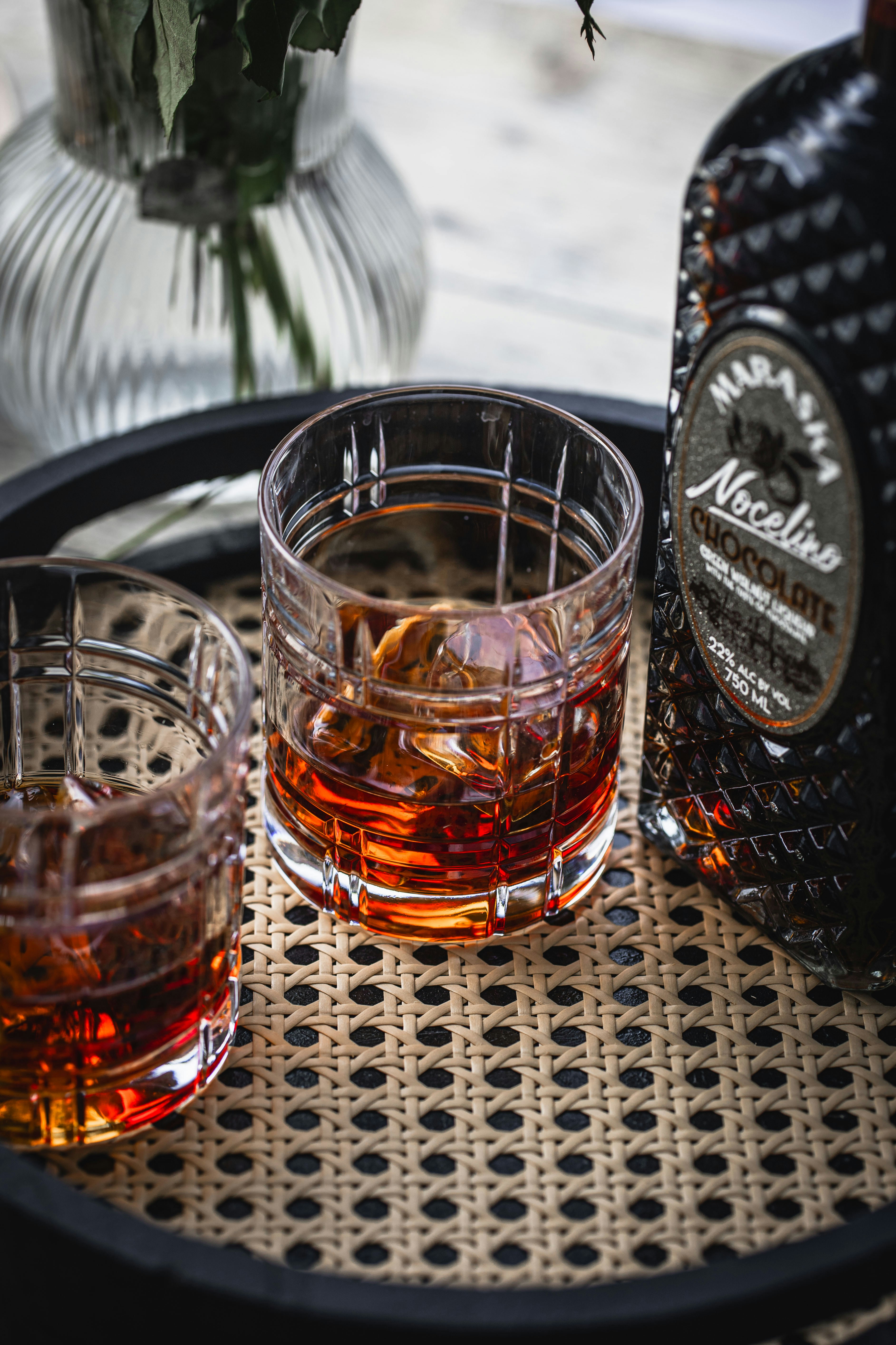 Two glasses of whiskey sit on a tray