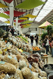 A market with lots of produce and people shopping