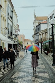 A woman walking down a street holding an umbrella