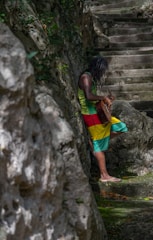 A woman in a colorful dress walking up a set of stairs