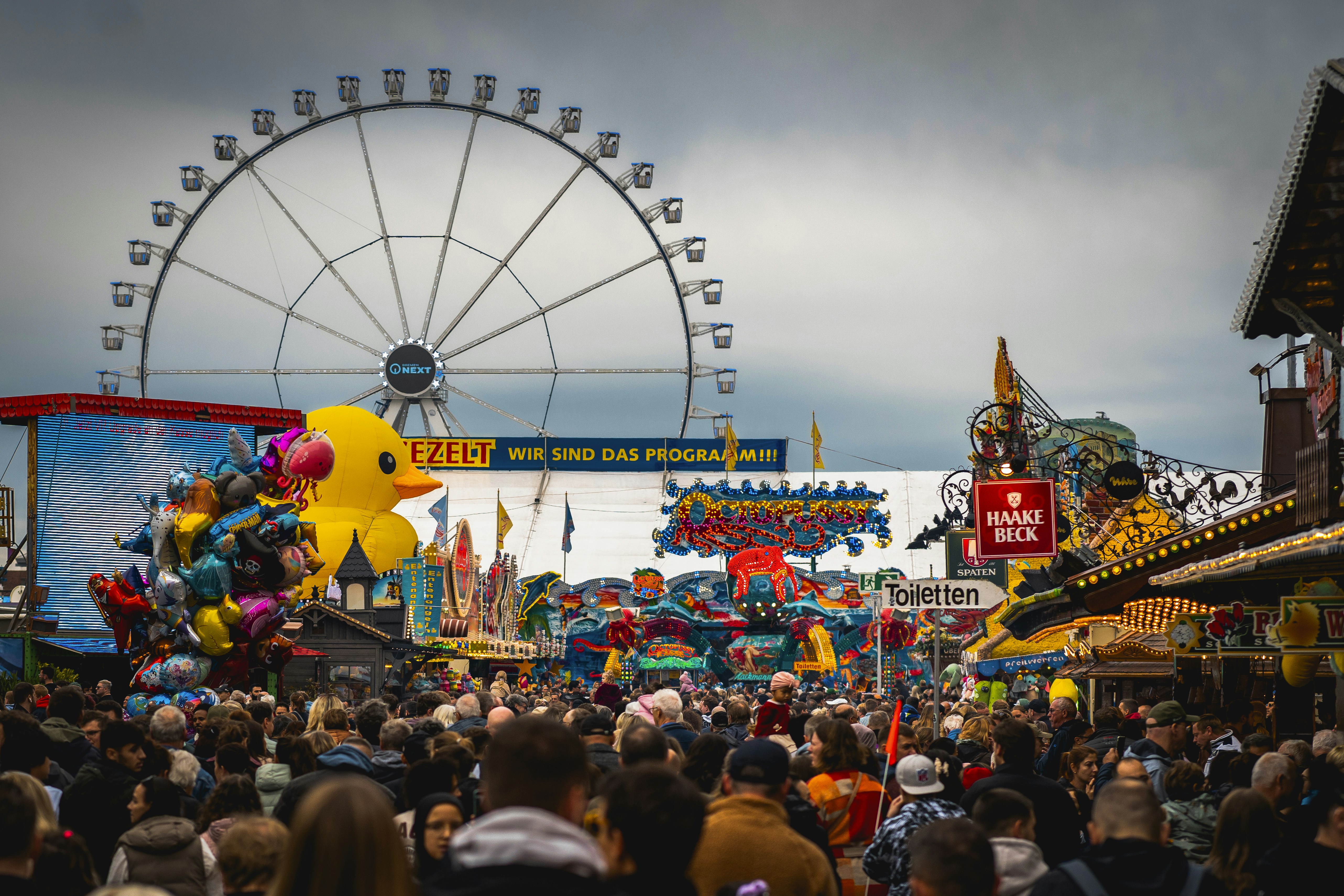 A crowd of people standing around a carnival