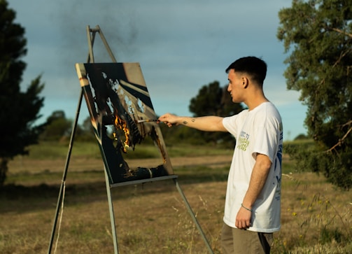 A man standing in front of a painting on a easel