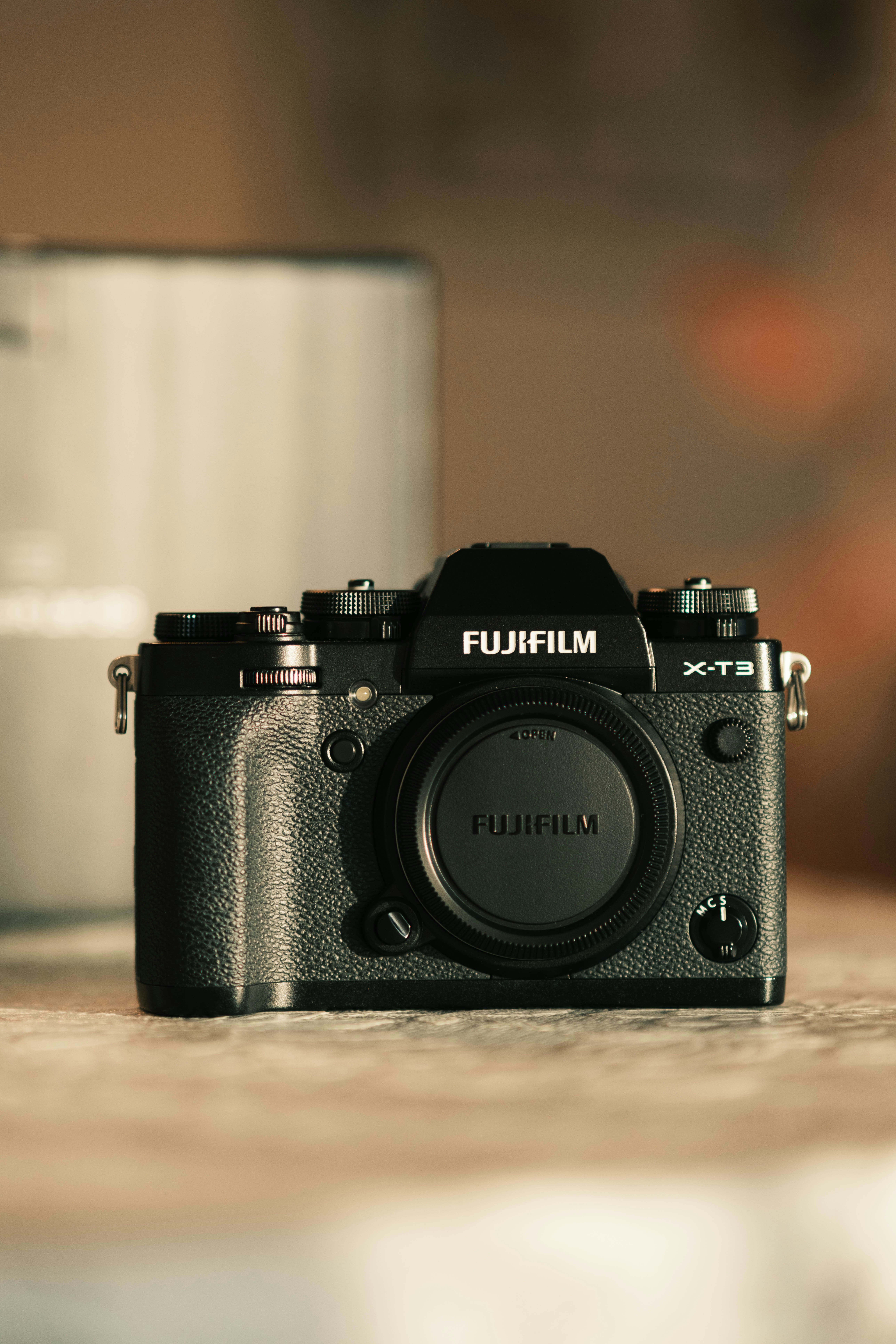 A camera sitting on a table next to a cup of coffee