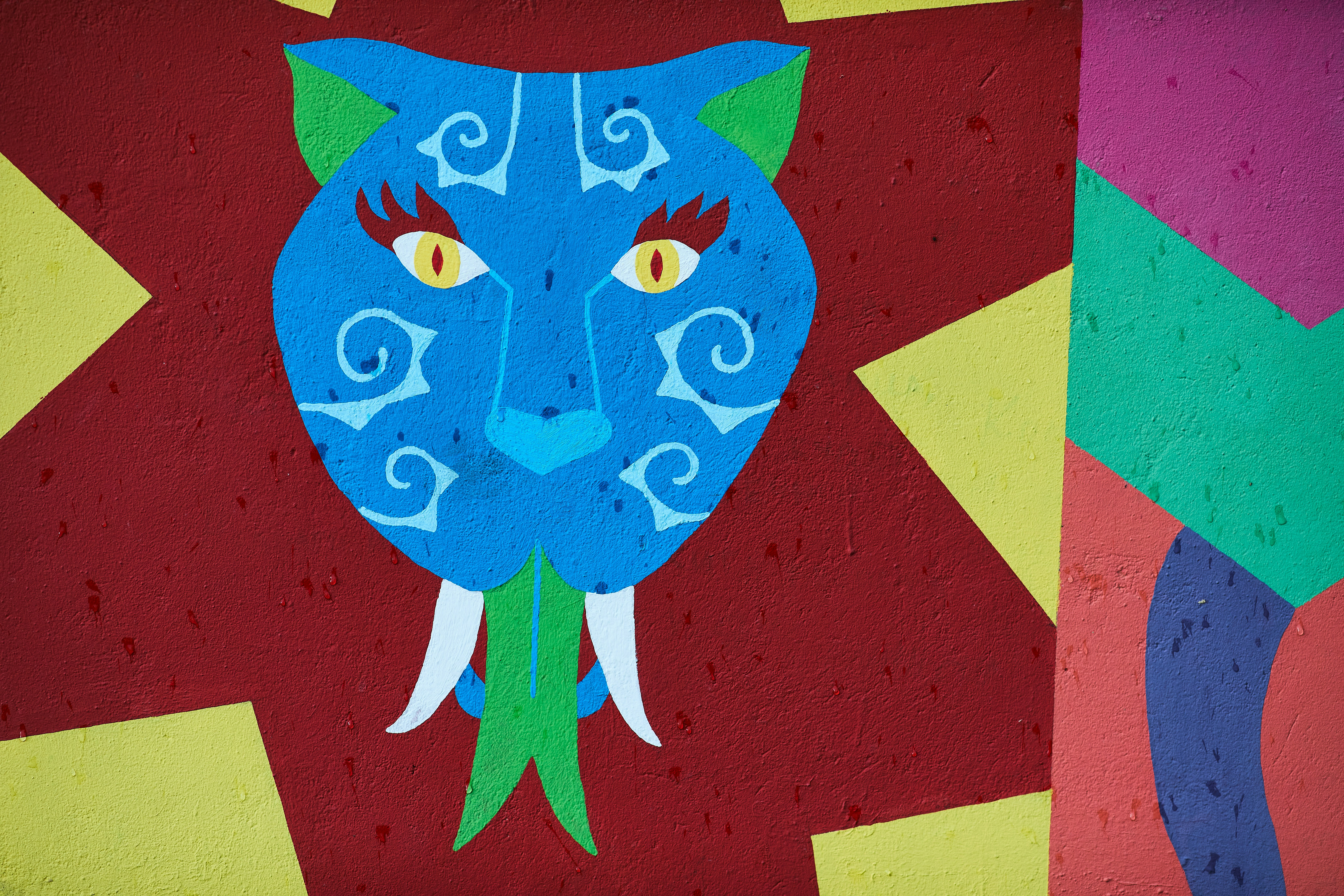 A painting of a blue cat with yellow eyes