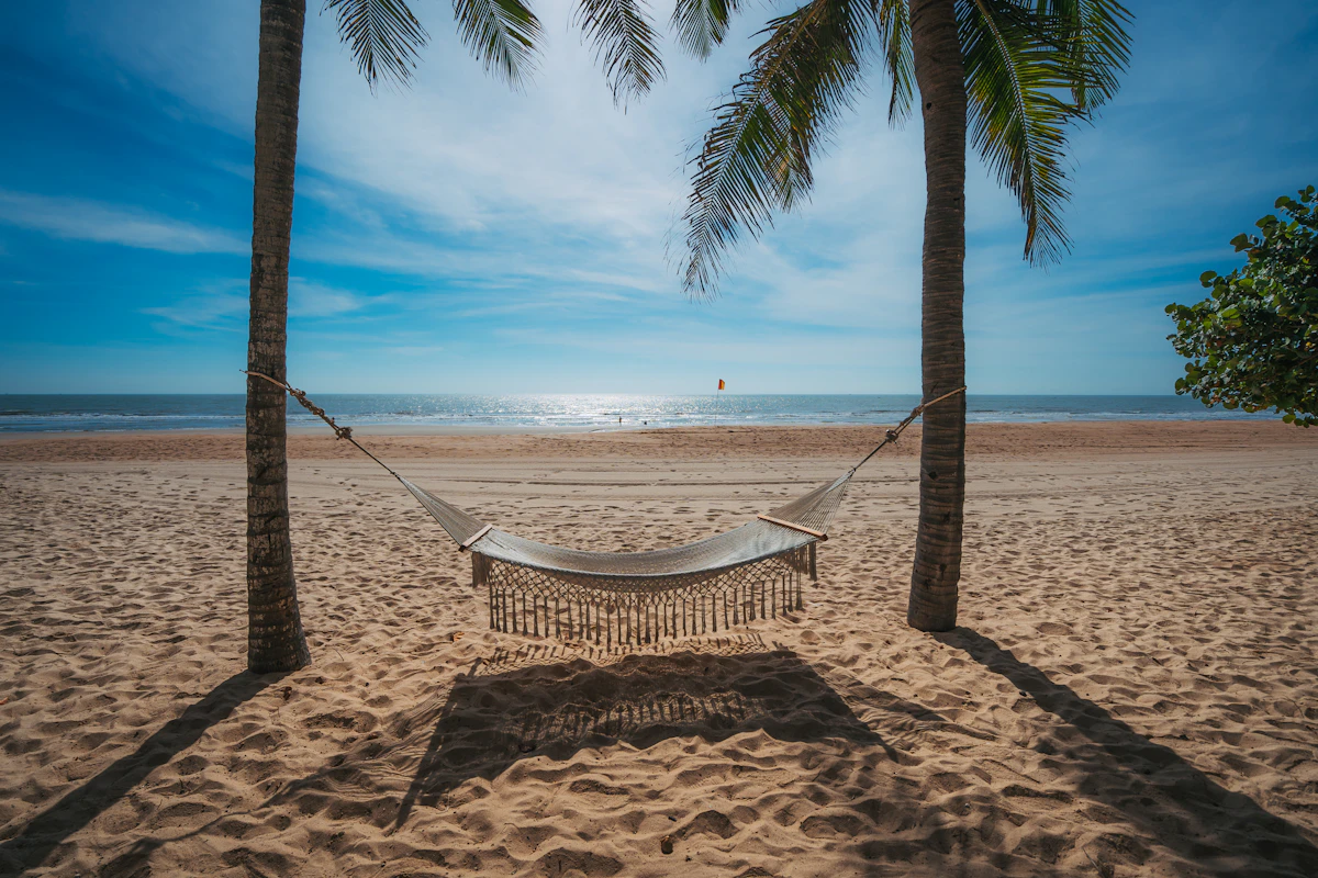 Hammock di pantai berpohon kelapa untuk cuti