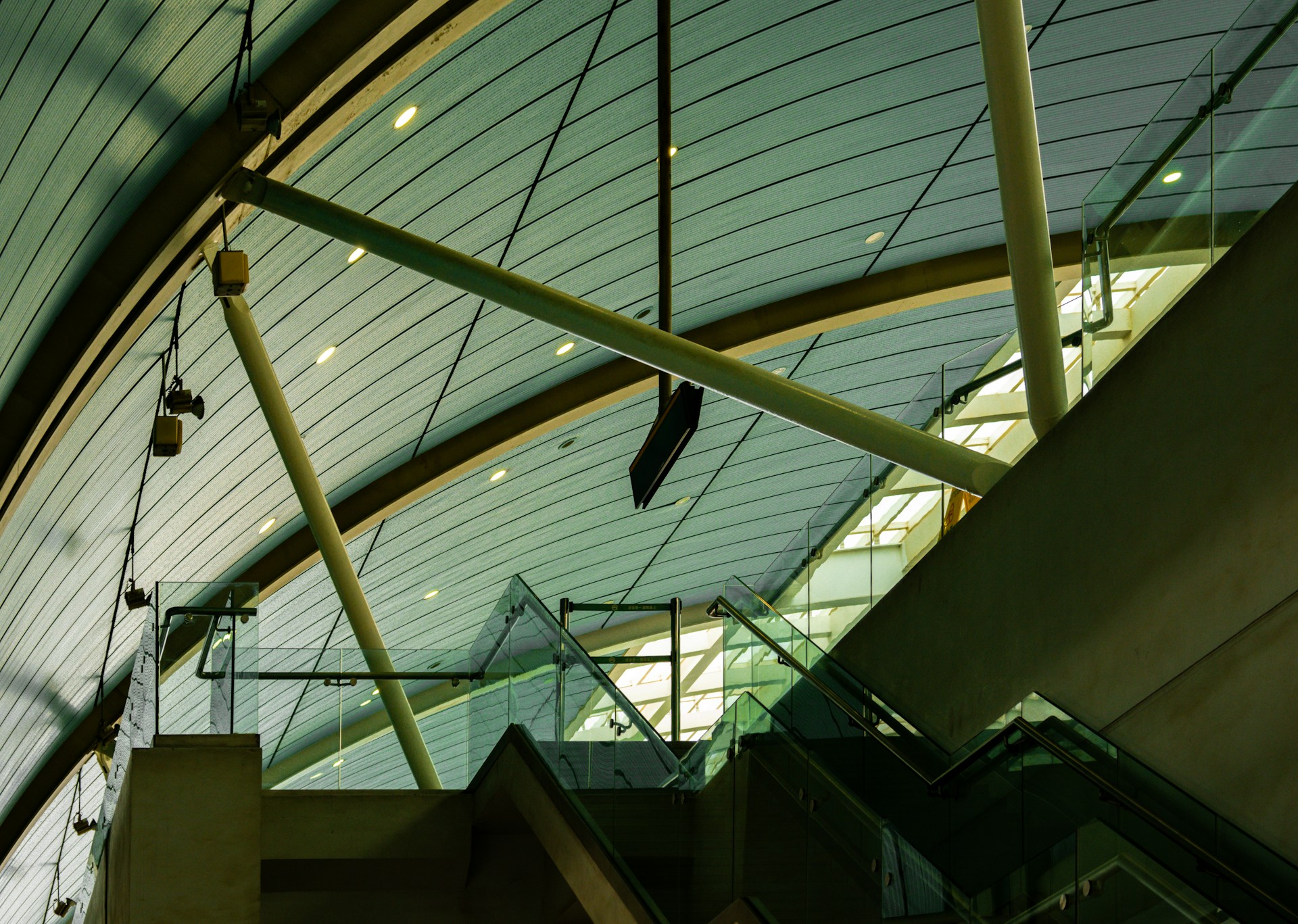 An escalator in a building with a glass ceiling