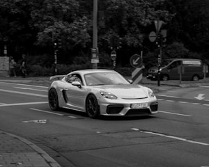 A white sports car driving down a street