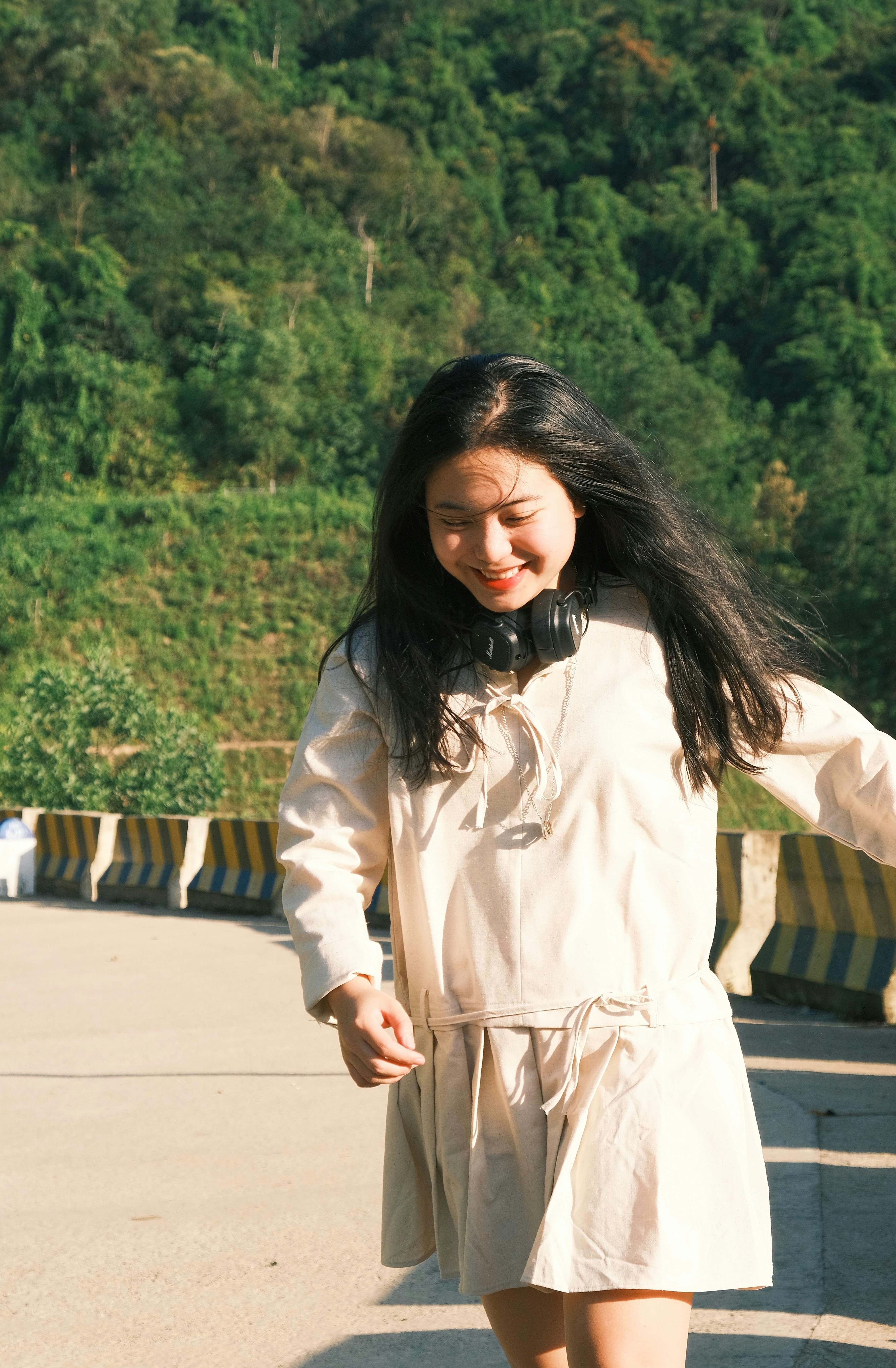 A woman in a white dress walking down a street photo – Free Forest ...