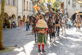 A group of people riding horses down a street