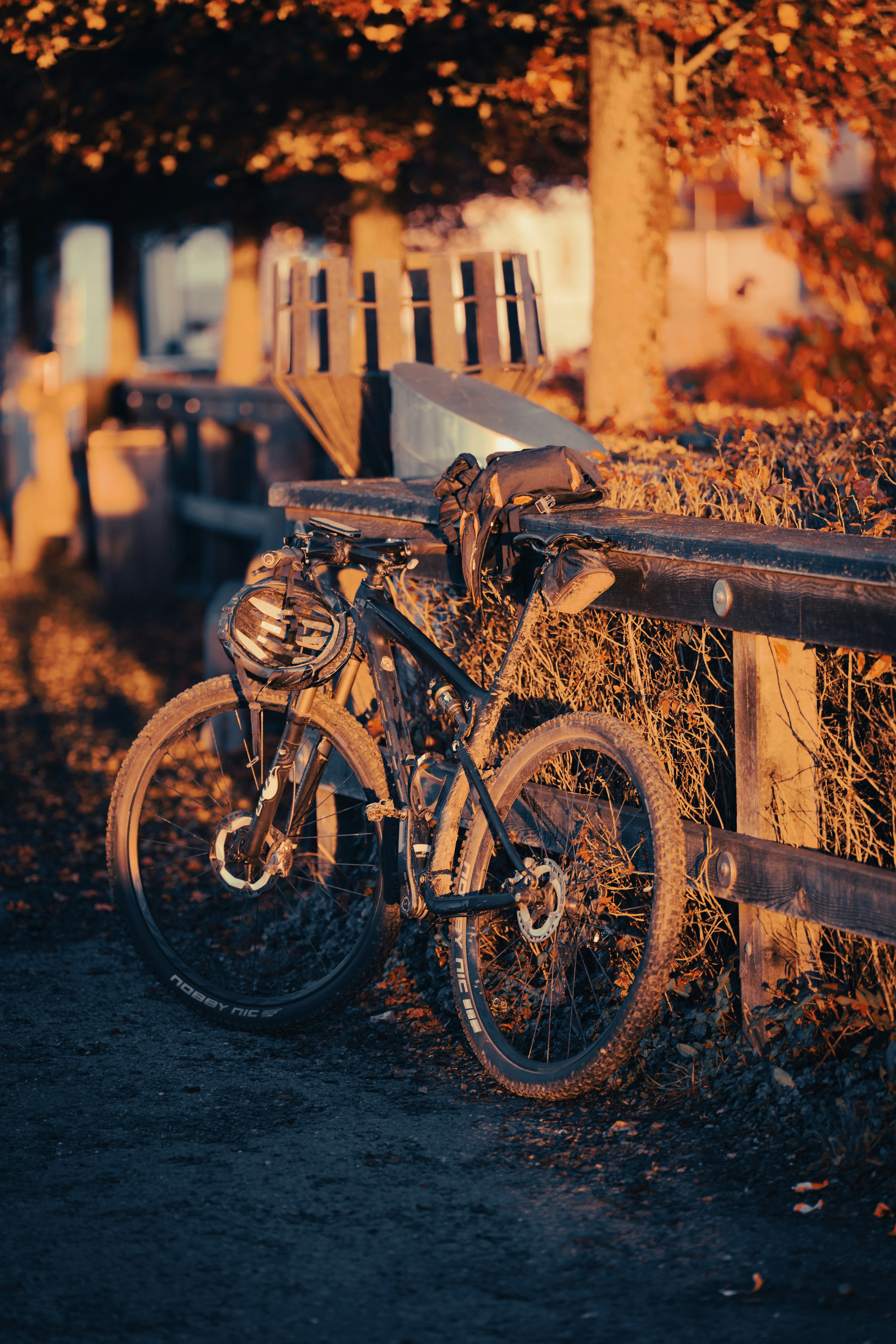 A bike parked next to a wooden fence