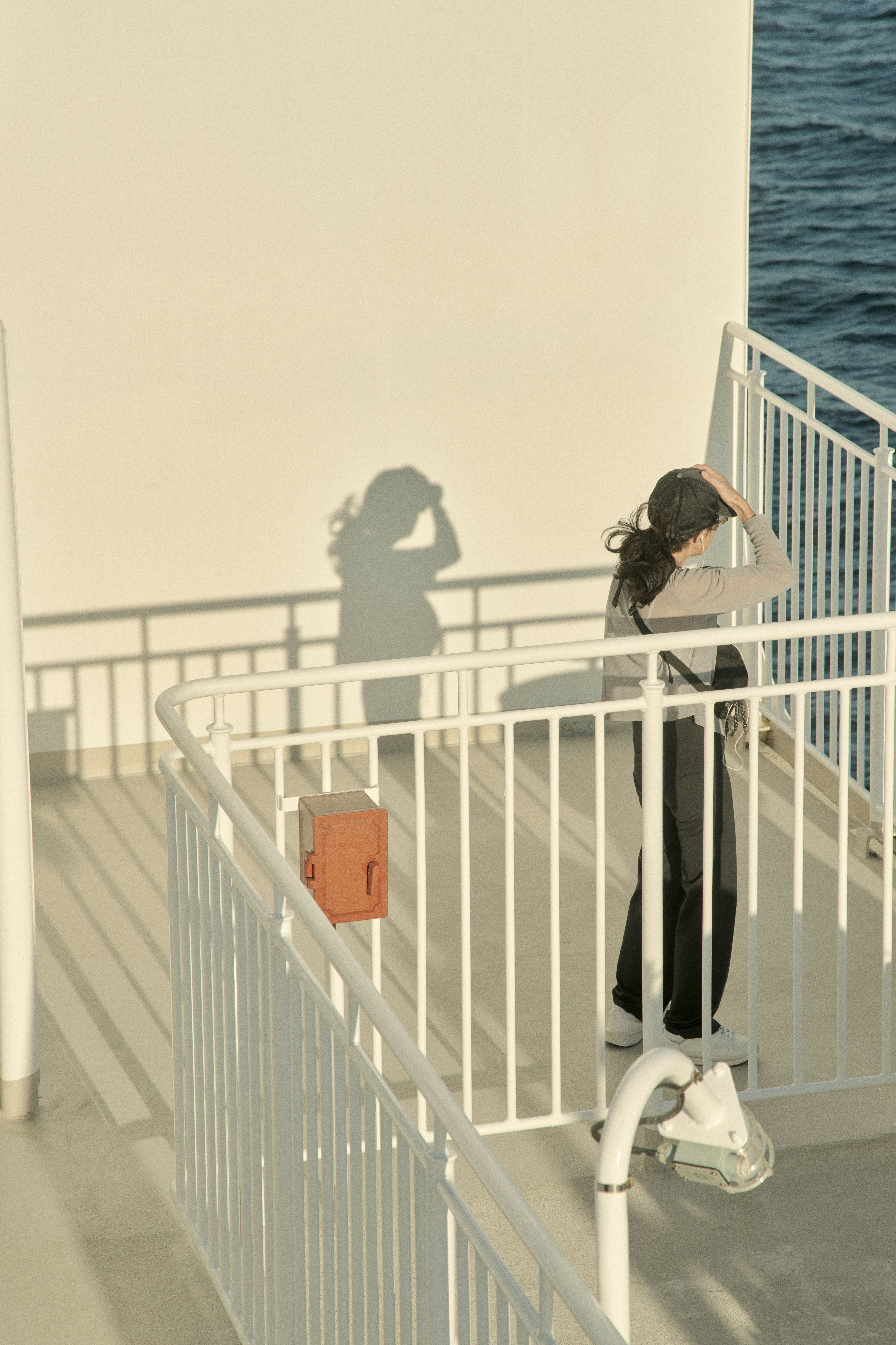 A woman standing on a railing next to a body of water photo – Free 影 ...