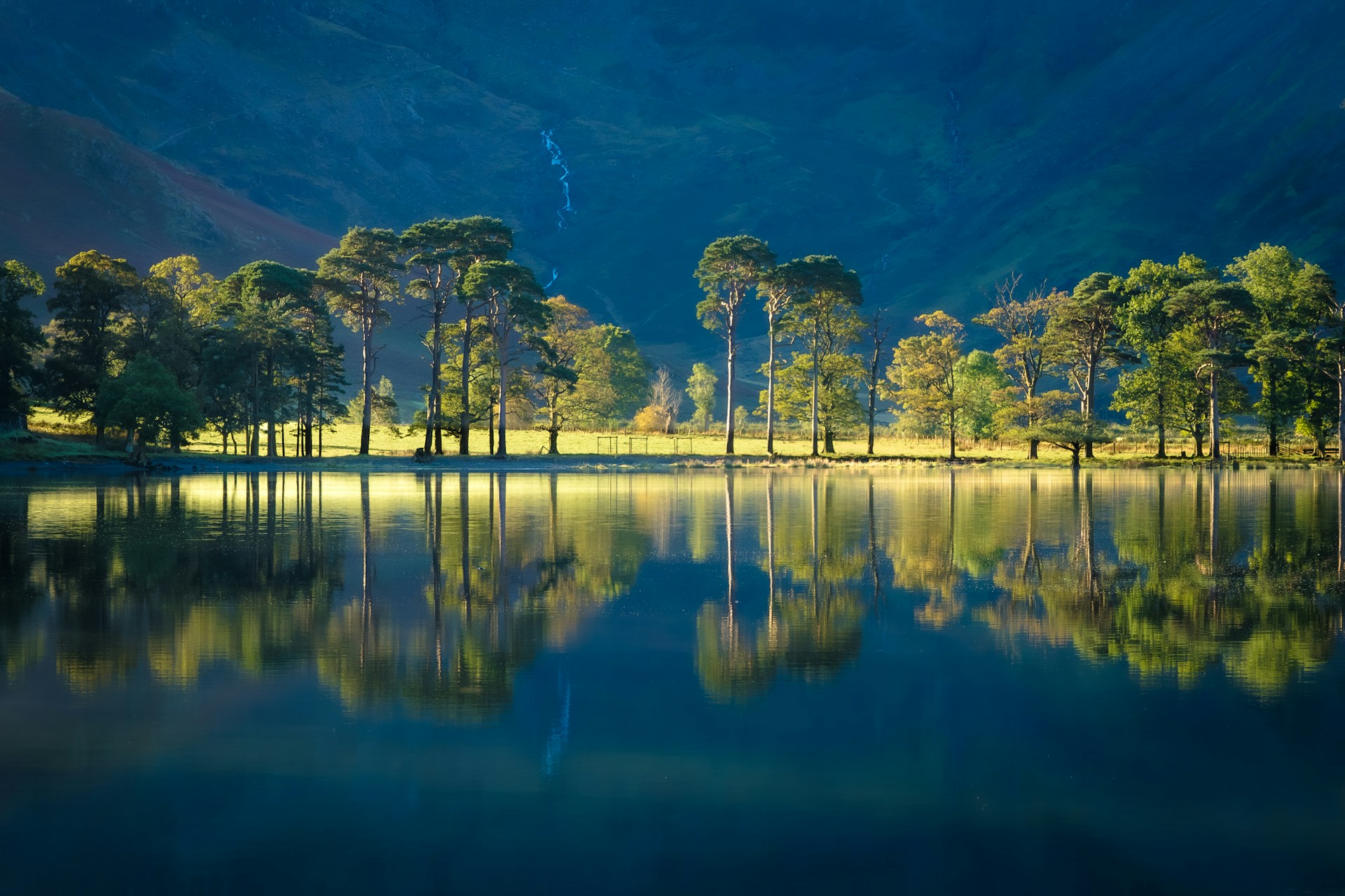 A body of water surrounded by mountains and trees