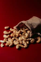 A bag full of cashews on a red background