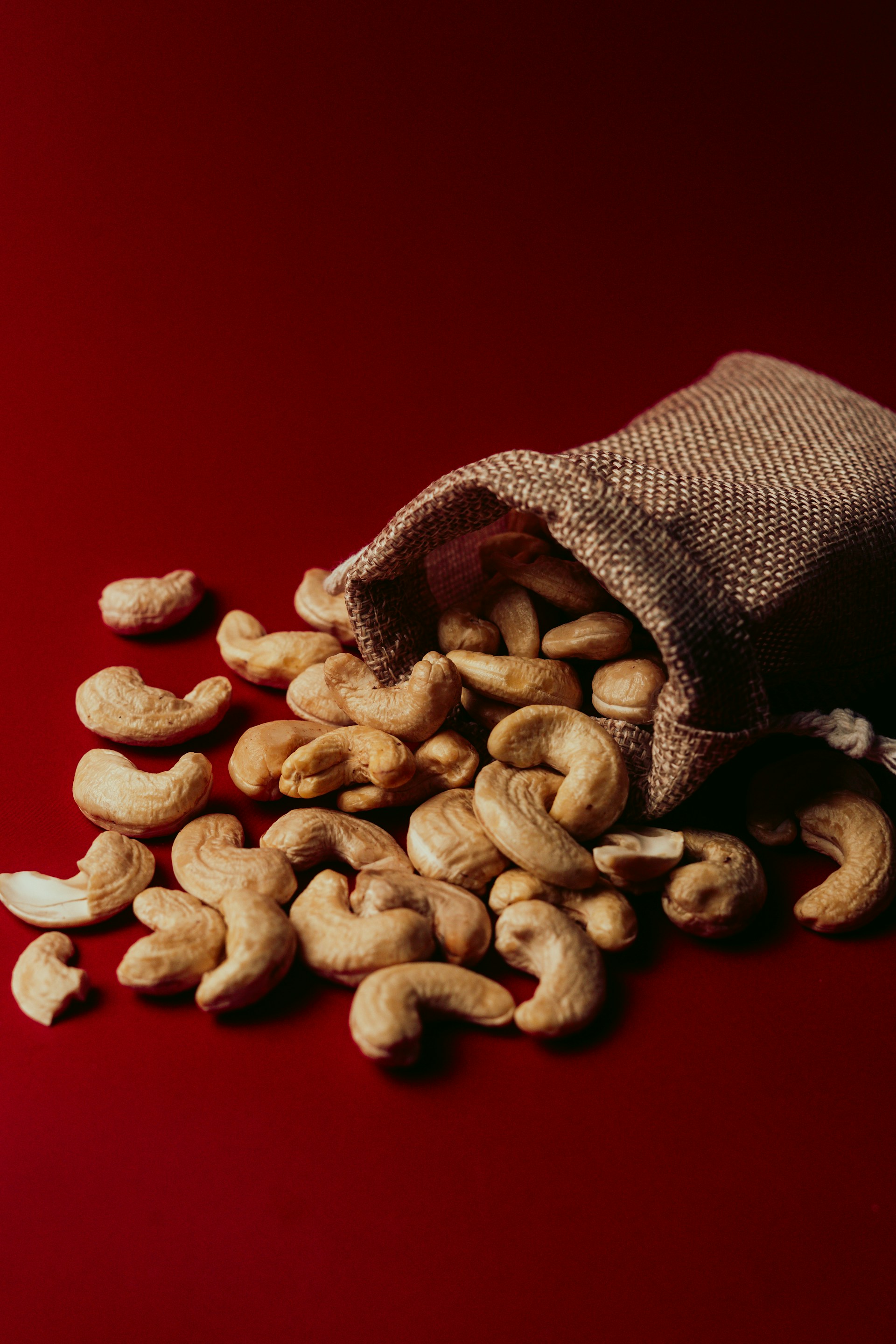 A bag full of cashews on a red background