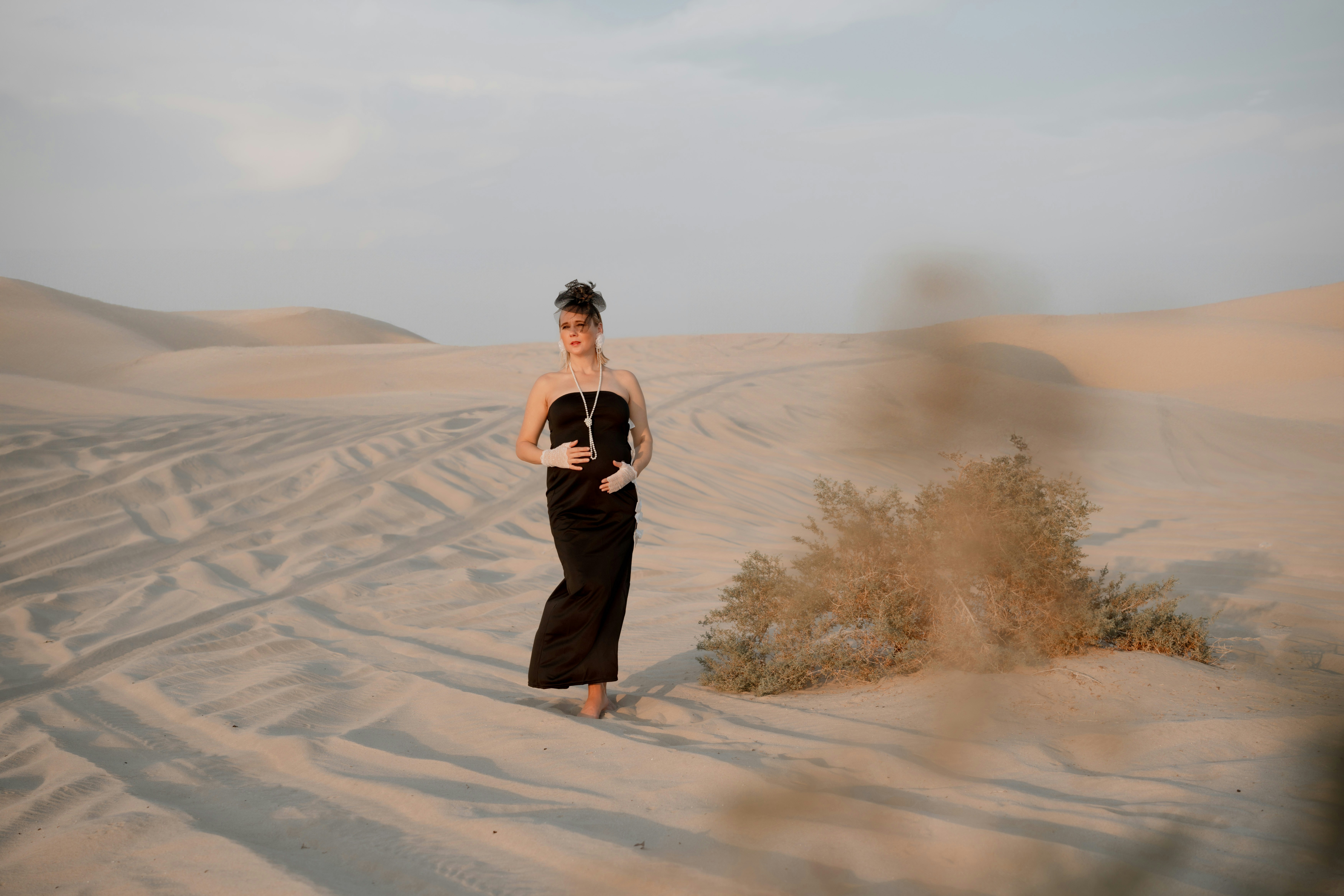 A woman standing in the middle of a desert