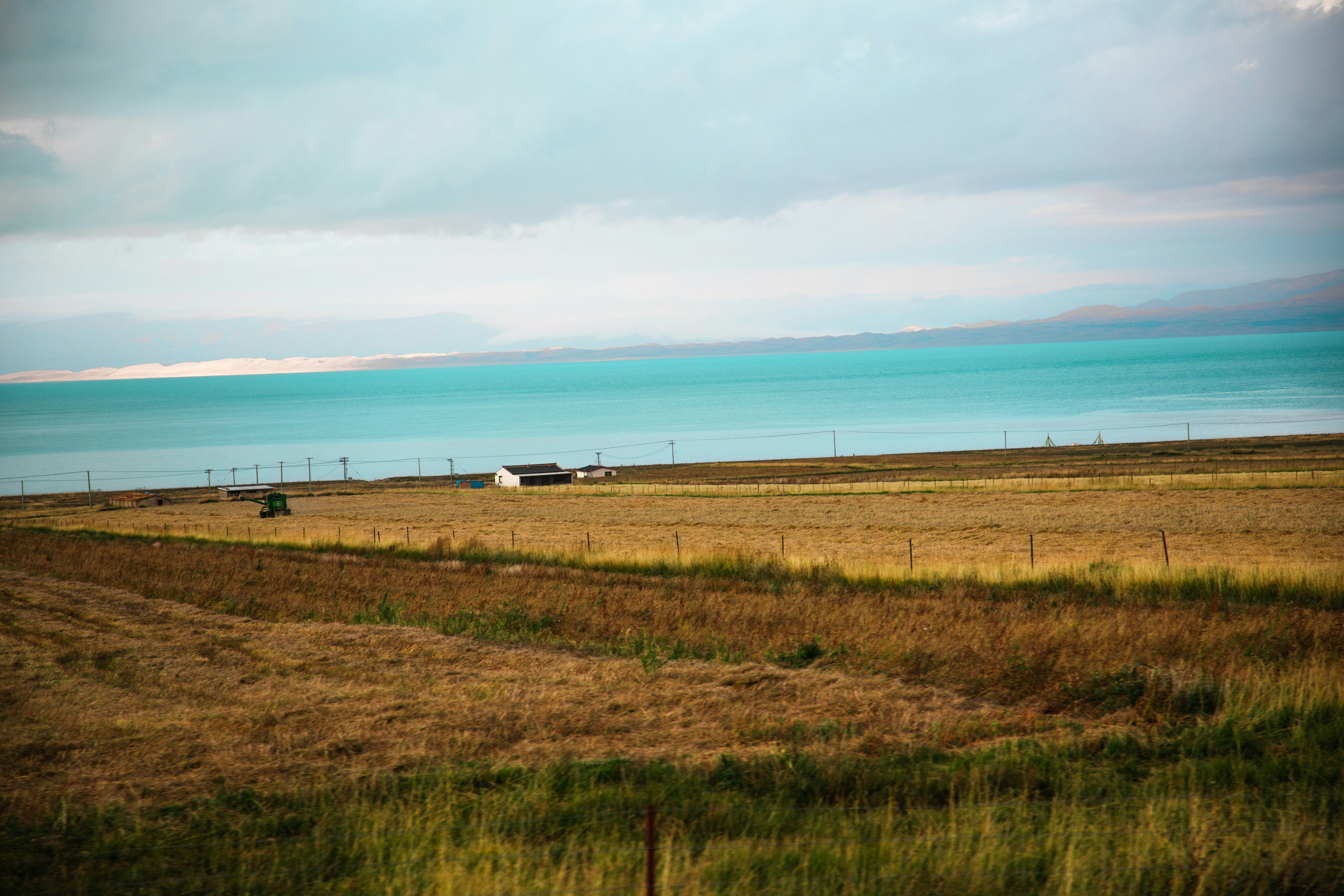 A grassy field with a body of water in the background