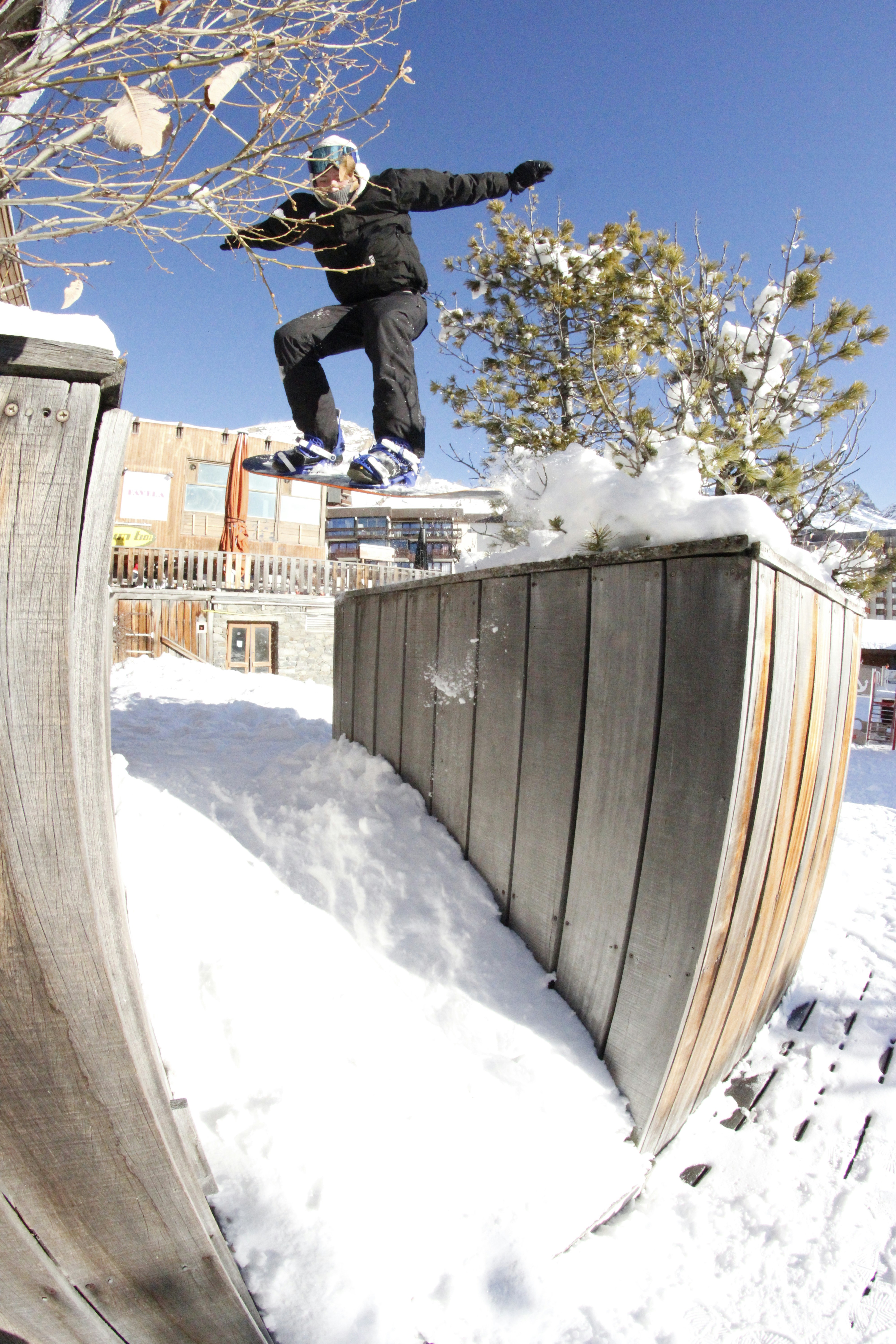 Un uomo che cavalca uno snowboard lungo il lato di una rampa