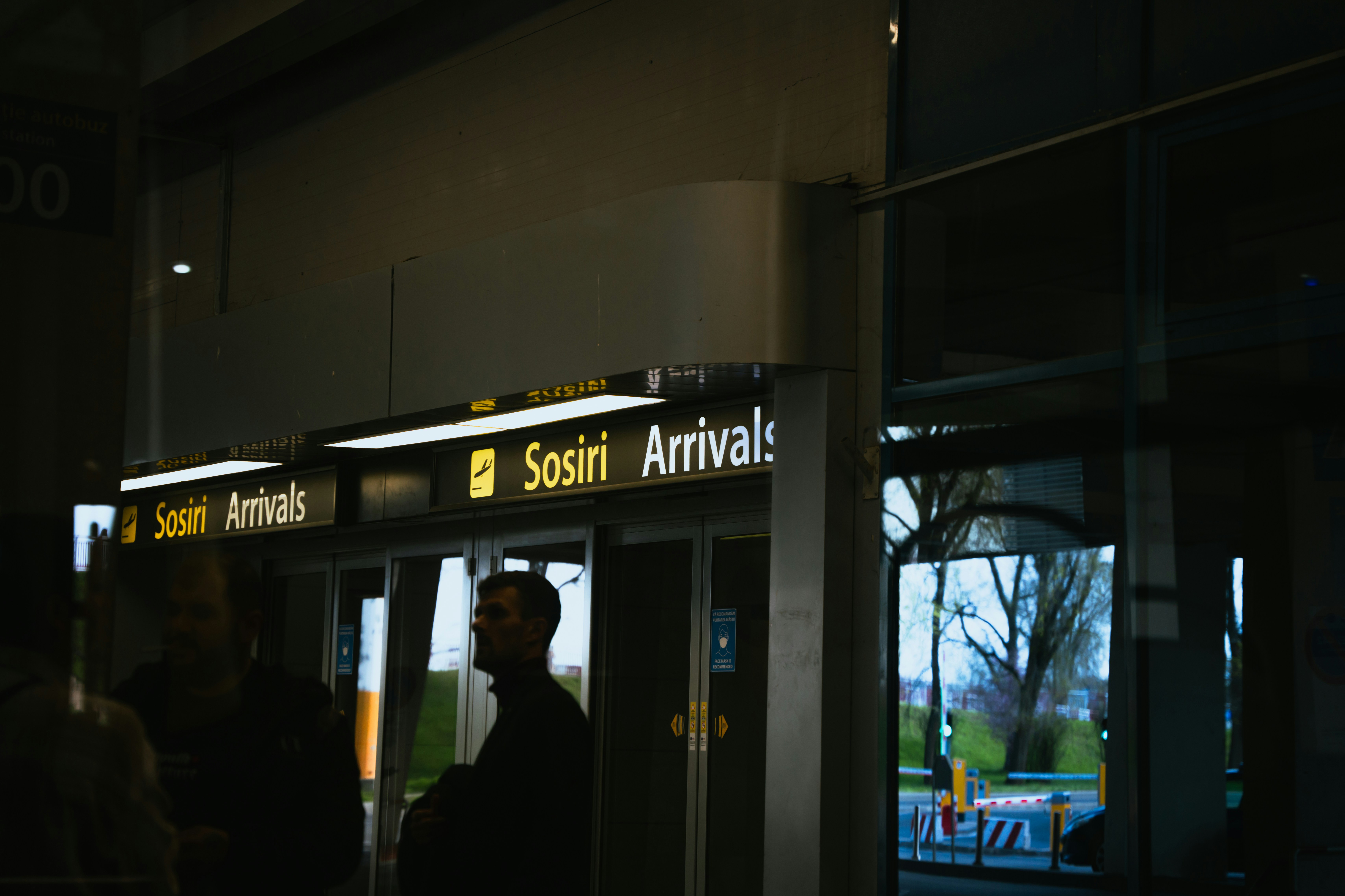 A group of people standing outside of a train station, 