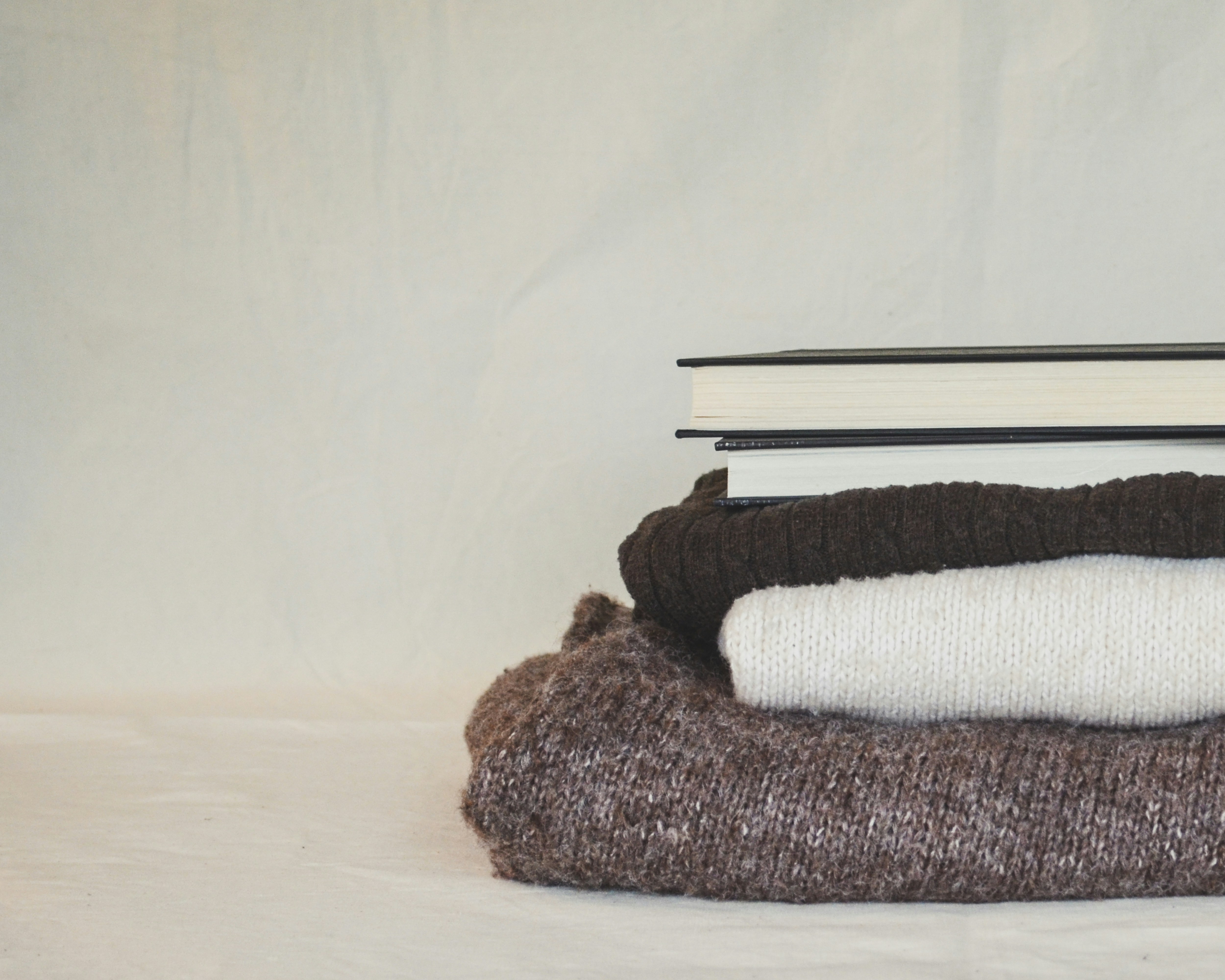 A stack of folded books sitting on top of a pile of blankets