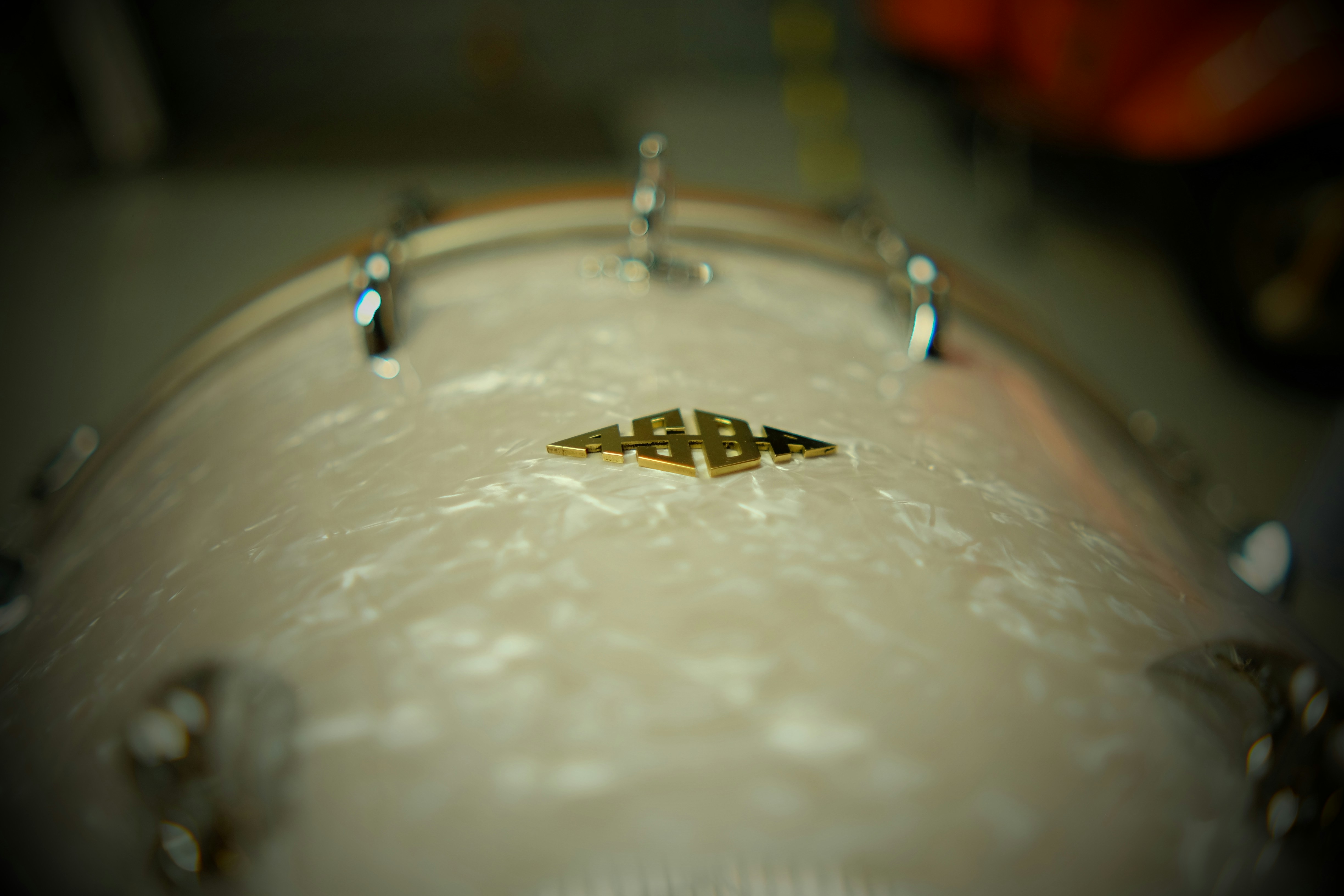 A close up of a white drum with a gold logo on it
