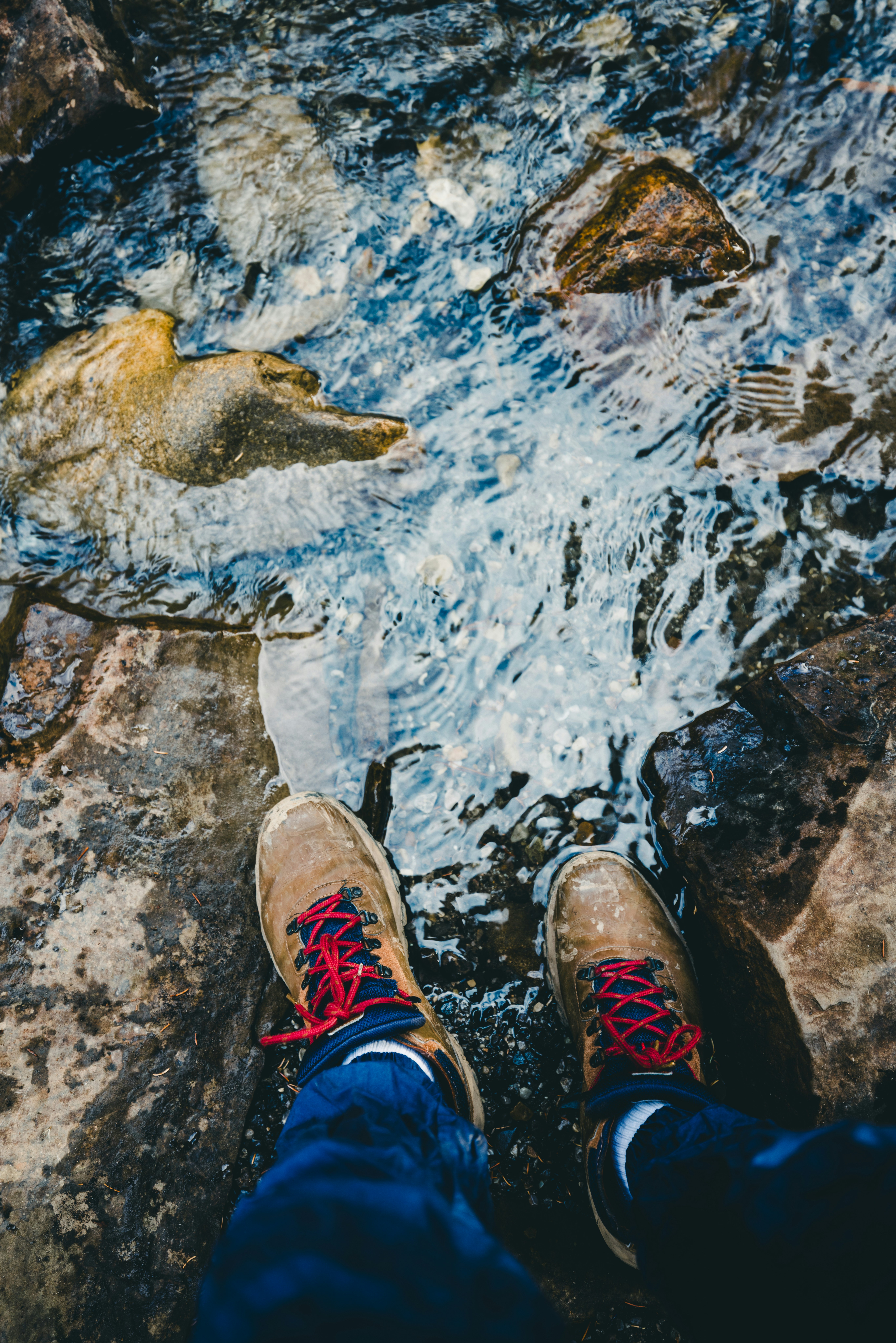 A person standing on a rock next to a river