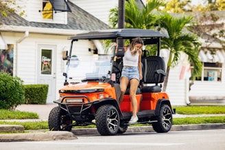 A woman riding on the back of a golf cart