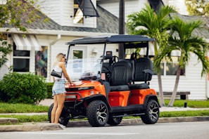 A woman standing next to a golf cart
