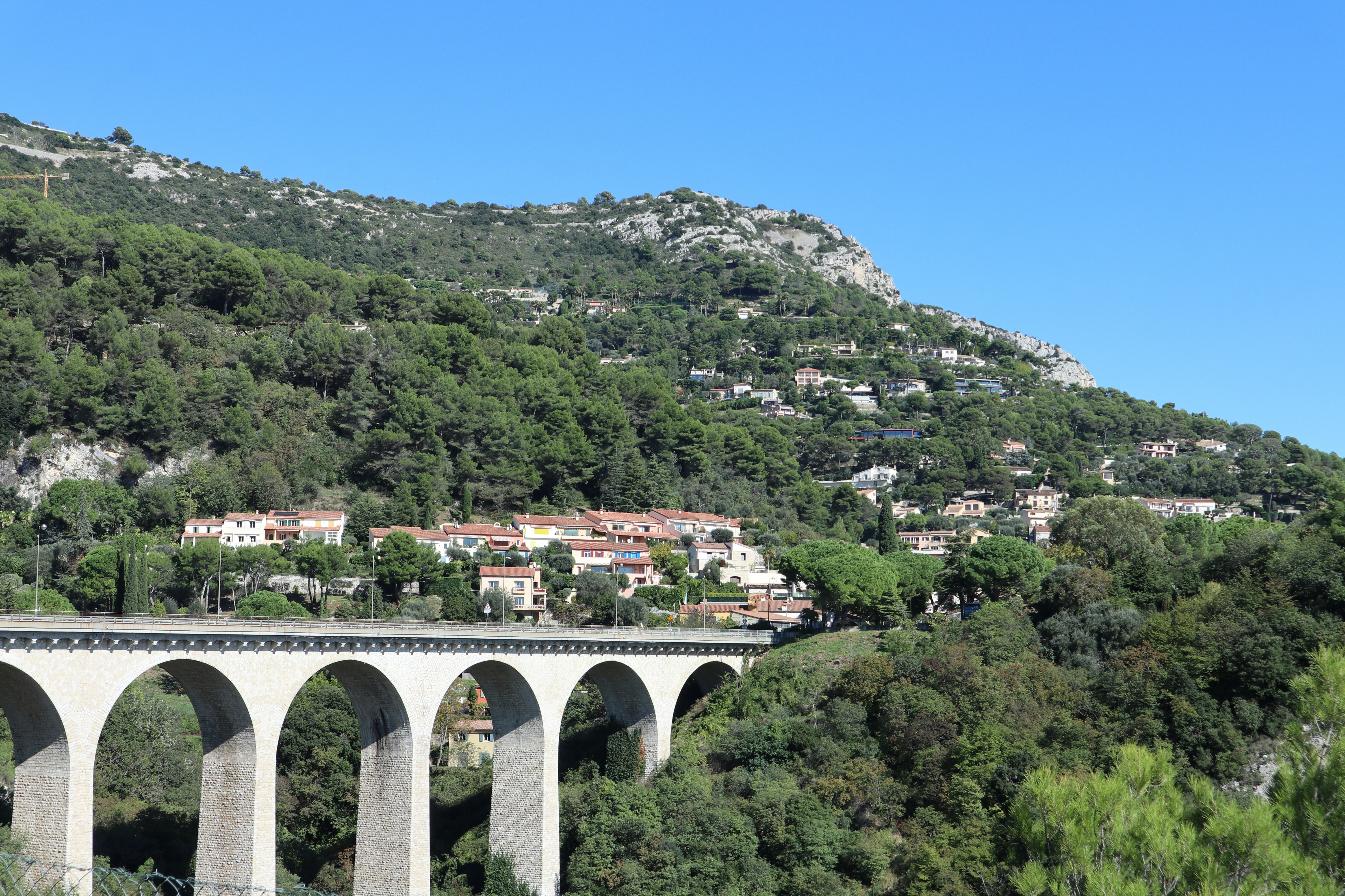 A bridge over a body of water with a mountain in the background