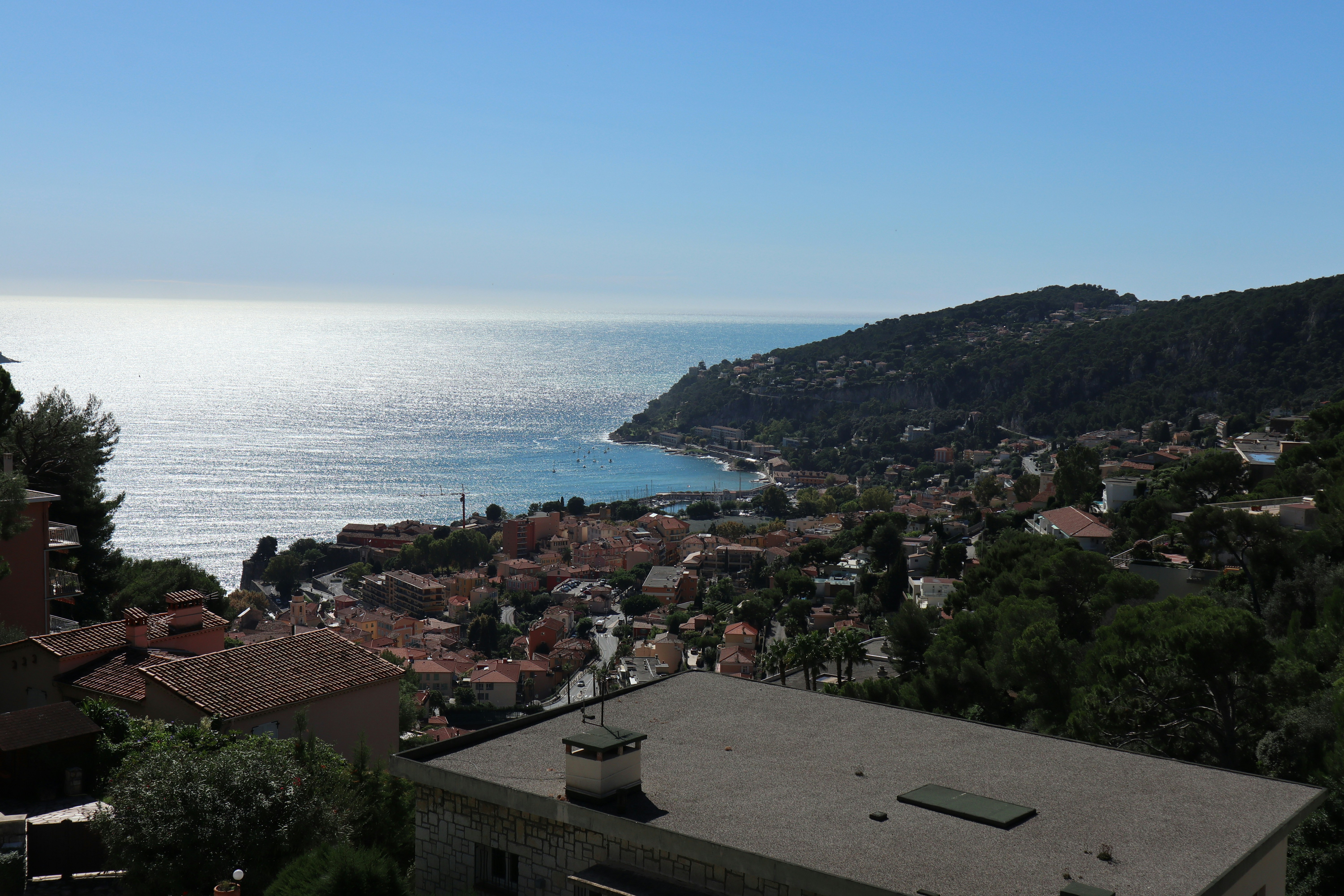 A view of a town and the ocean from a hill
