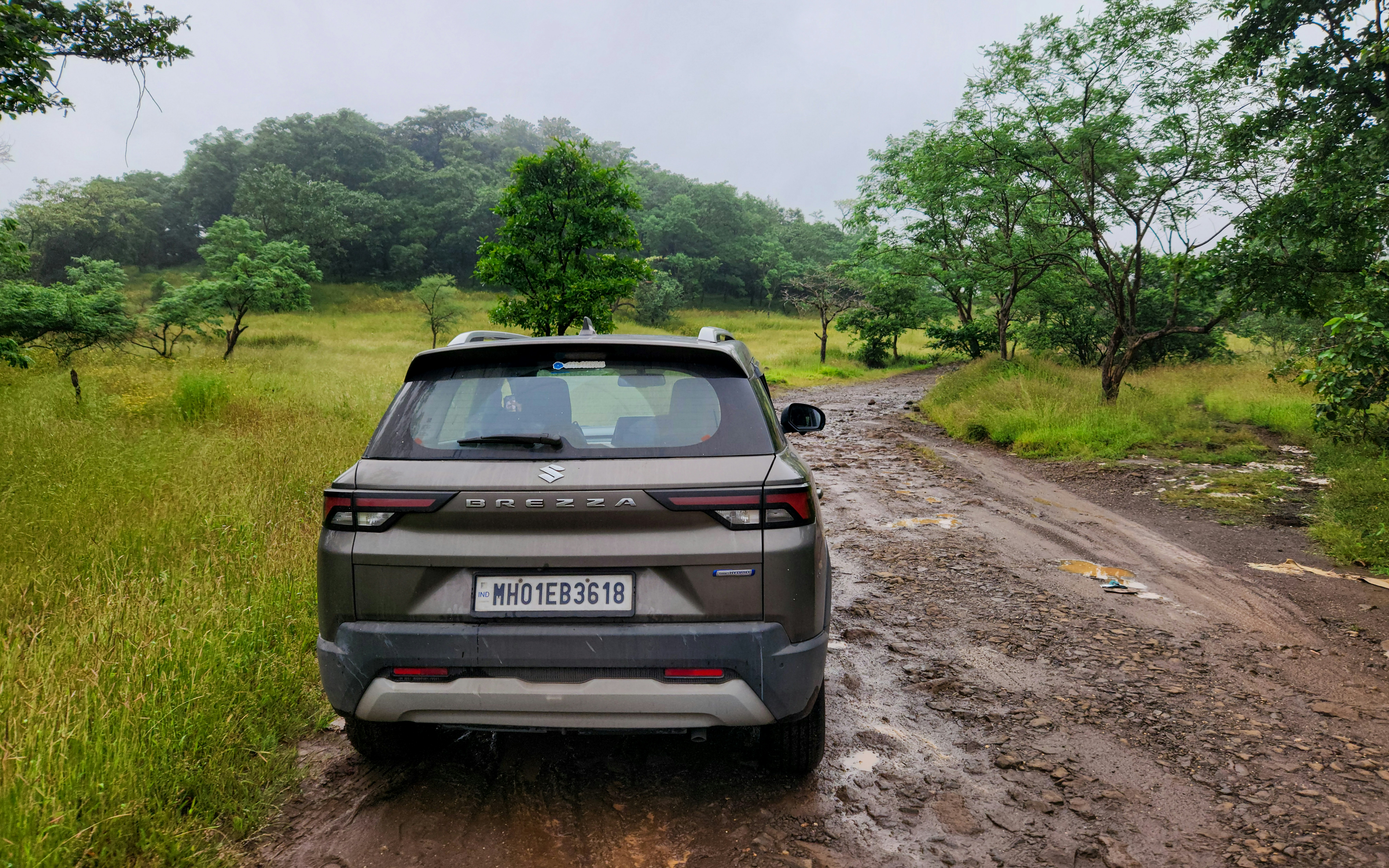 A car is driving down a muddy road