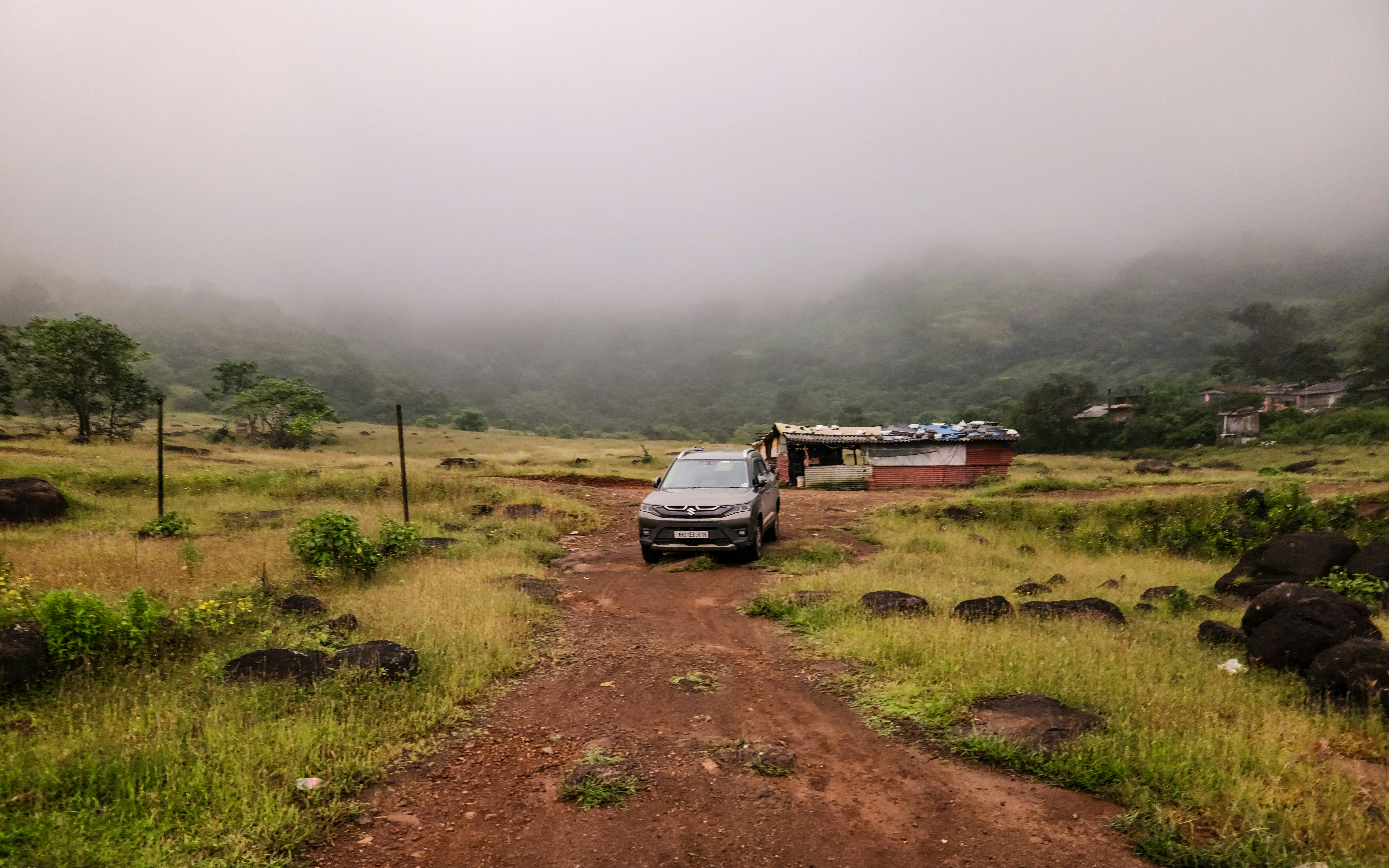 A truck parked on a dirt road in the middle of a field