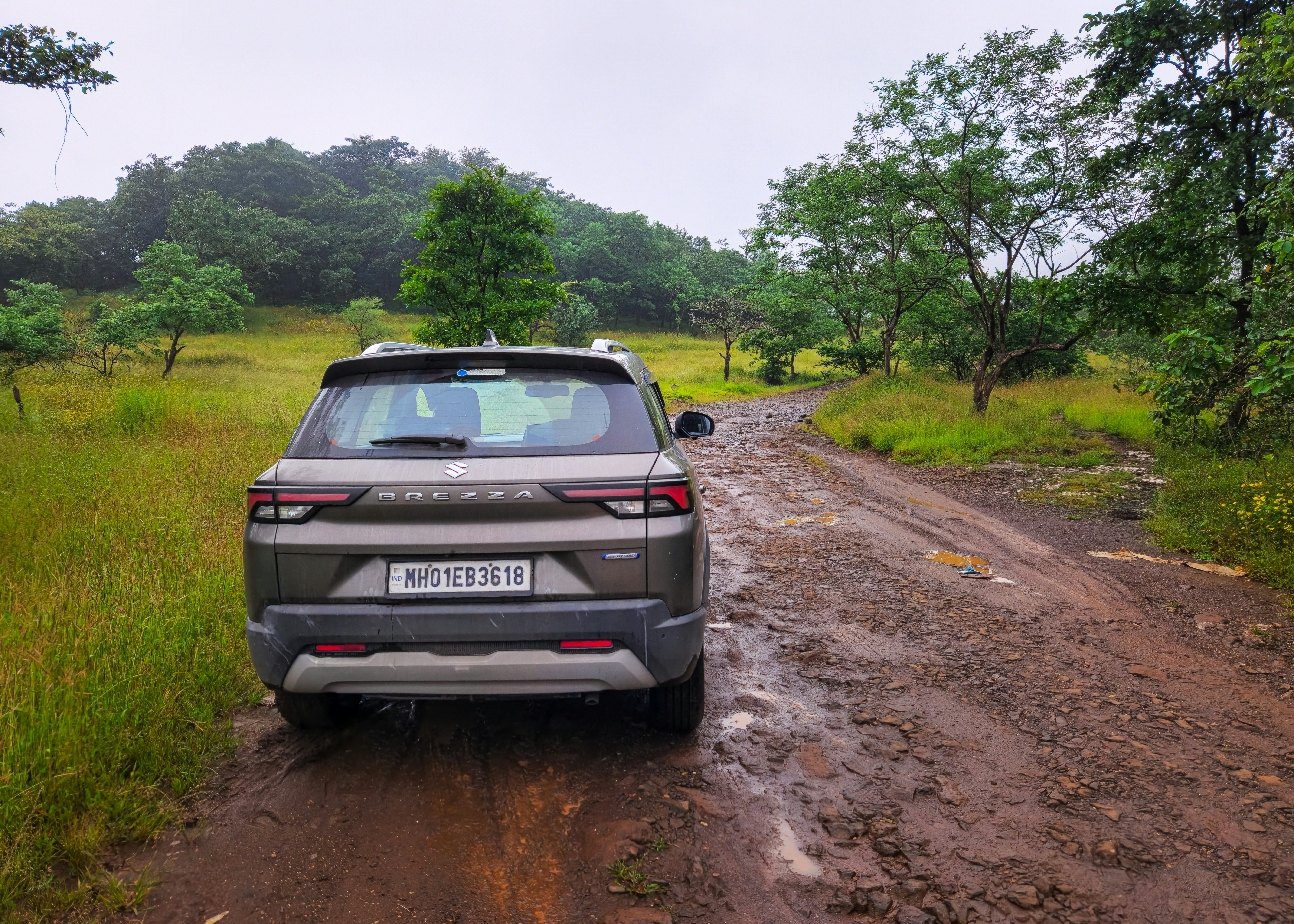 A car parked on the side of a dirt road