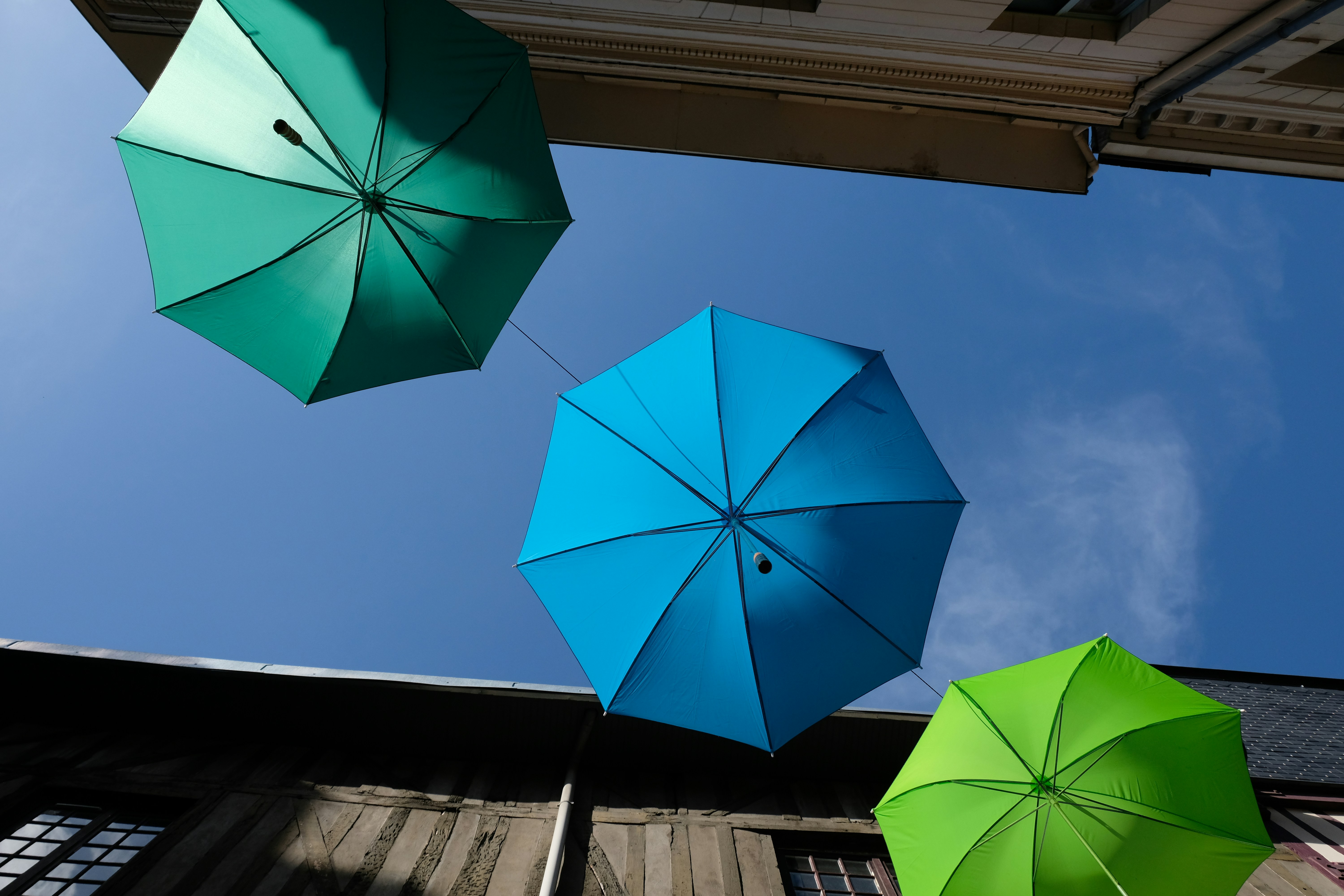 A group of three umbrellas hanging from the side of a building