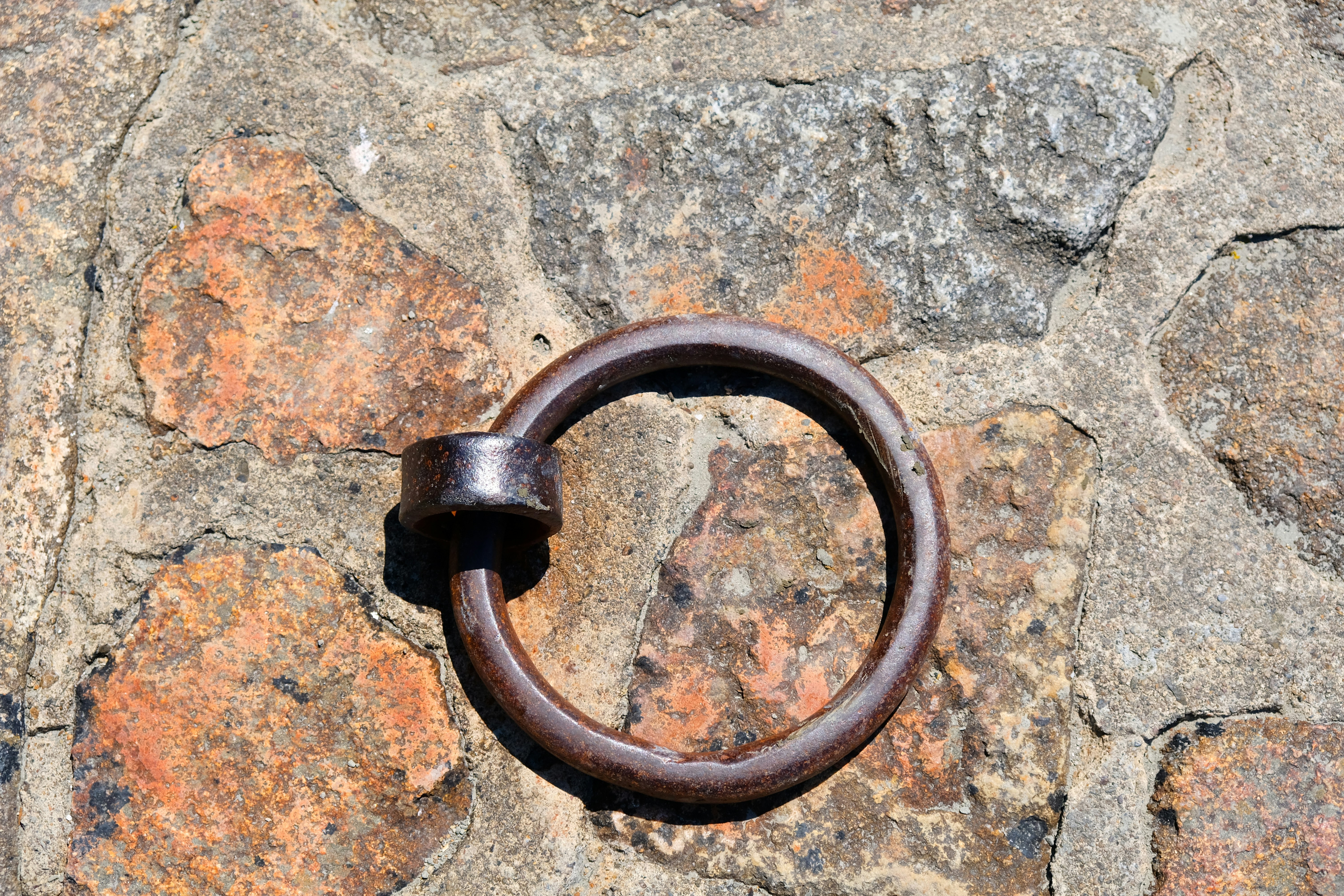 A close up of a metal ring on a stone wall
