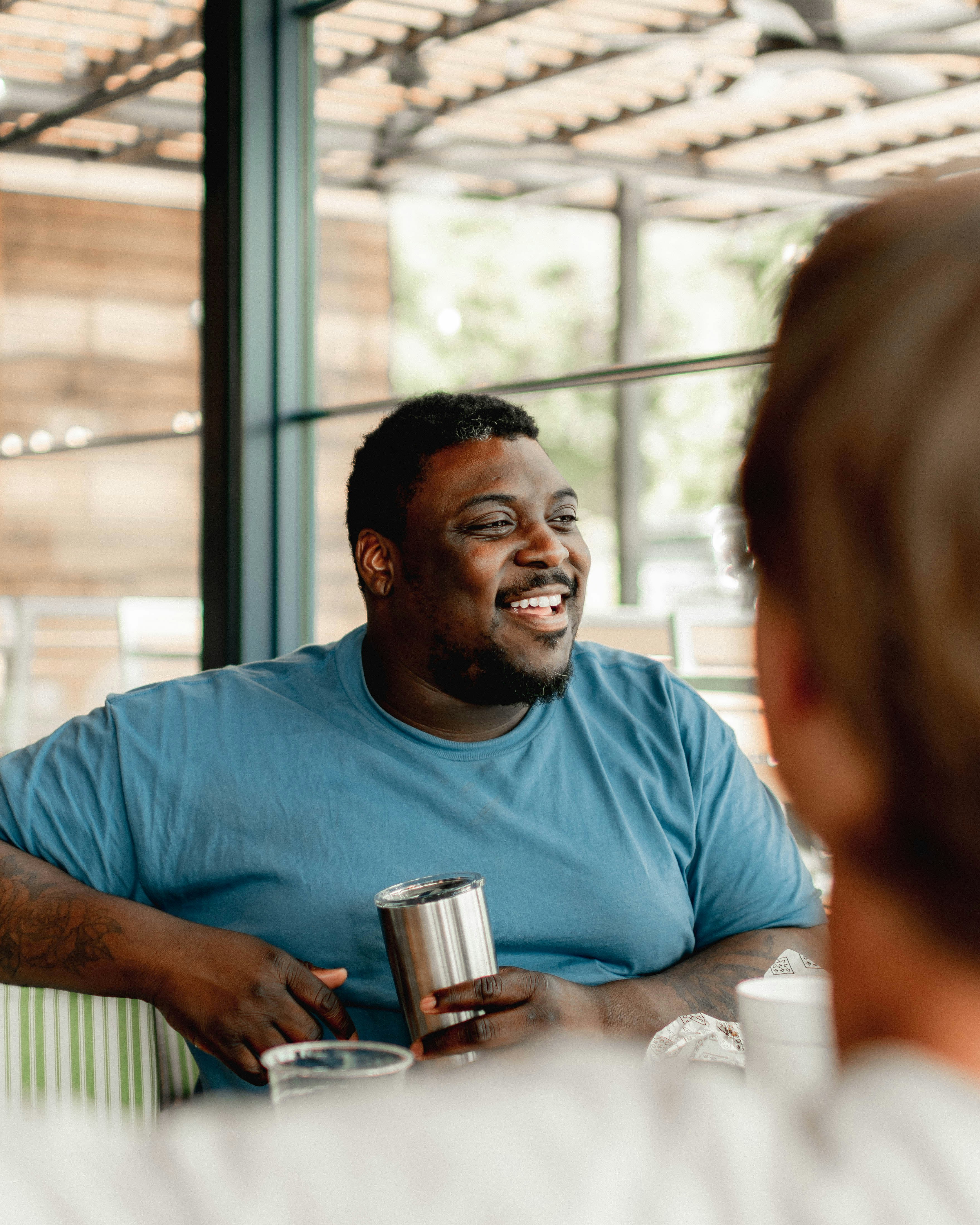 A man sitting at a table talking to another man