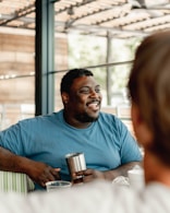 A man sitting at a table talking to another man