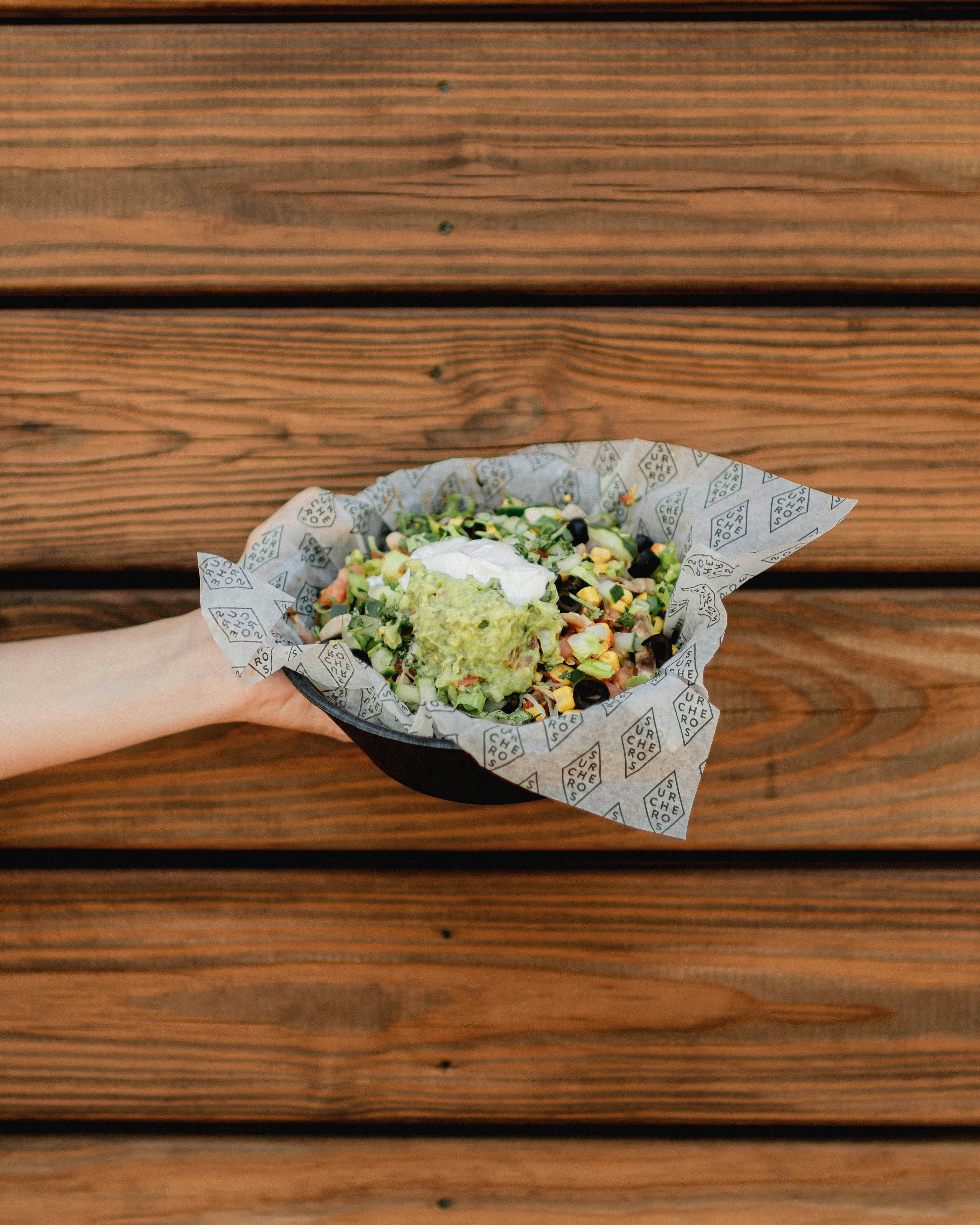 A person holding a paper bag filled with food