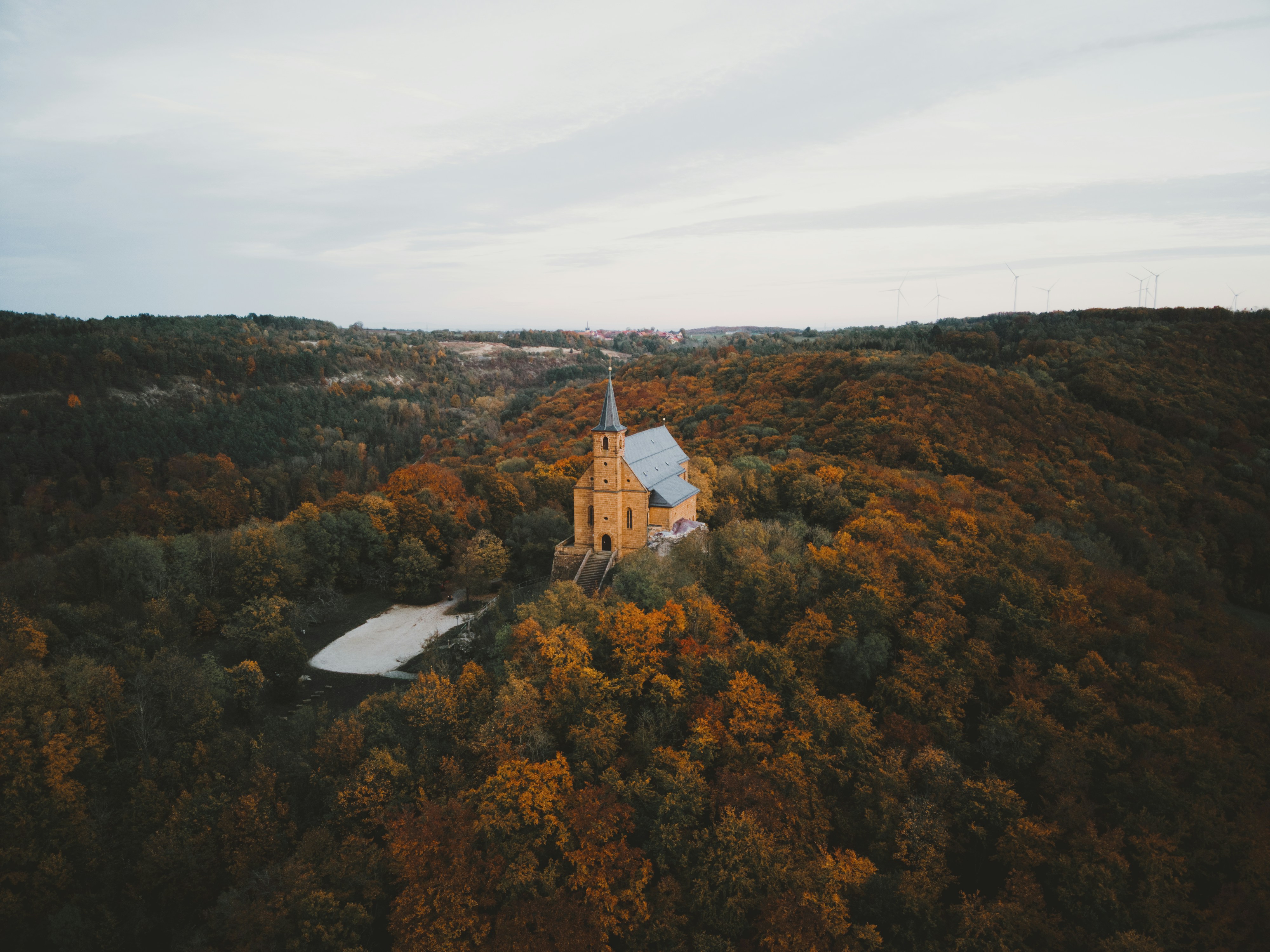 An aerial view of a church surrounded by trees