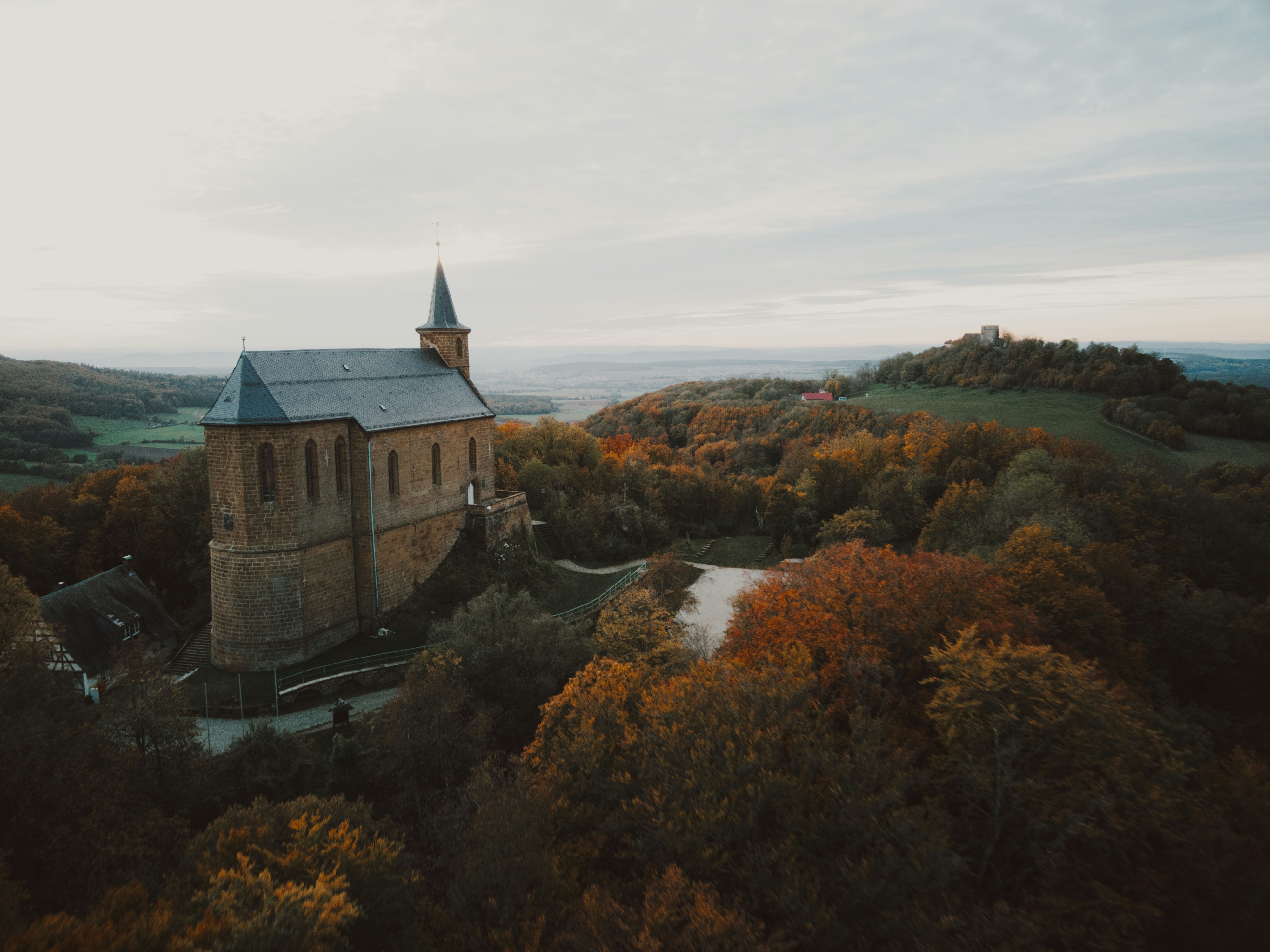 An aerial view of a church surrounded by trees