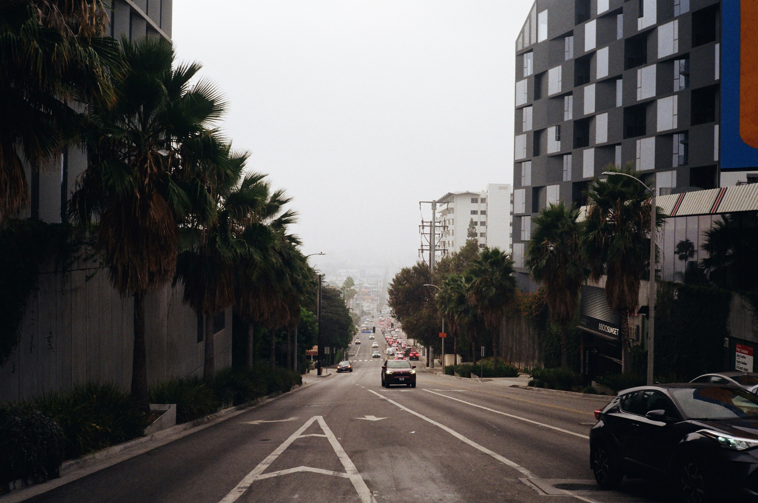 A car driving down a street next to tall buildings