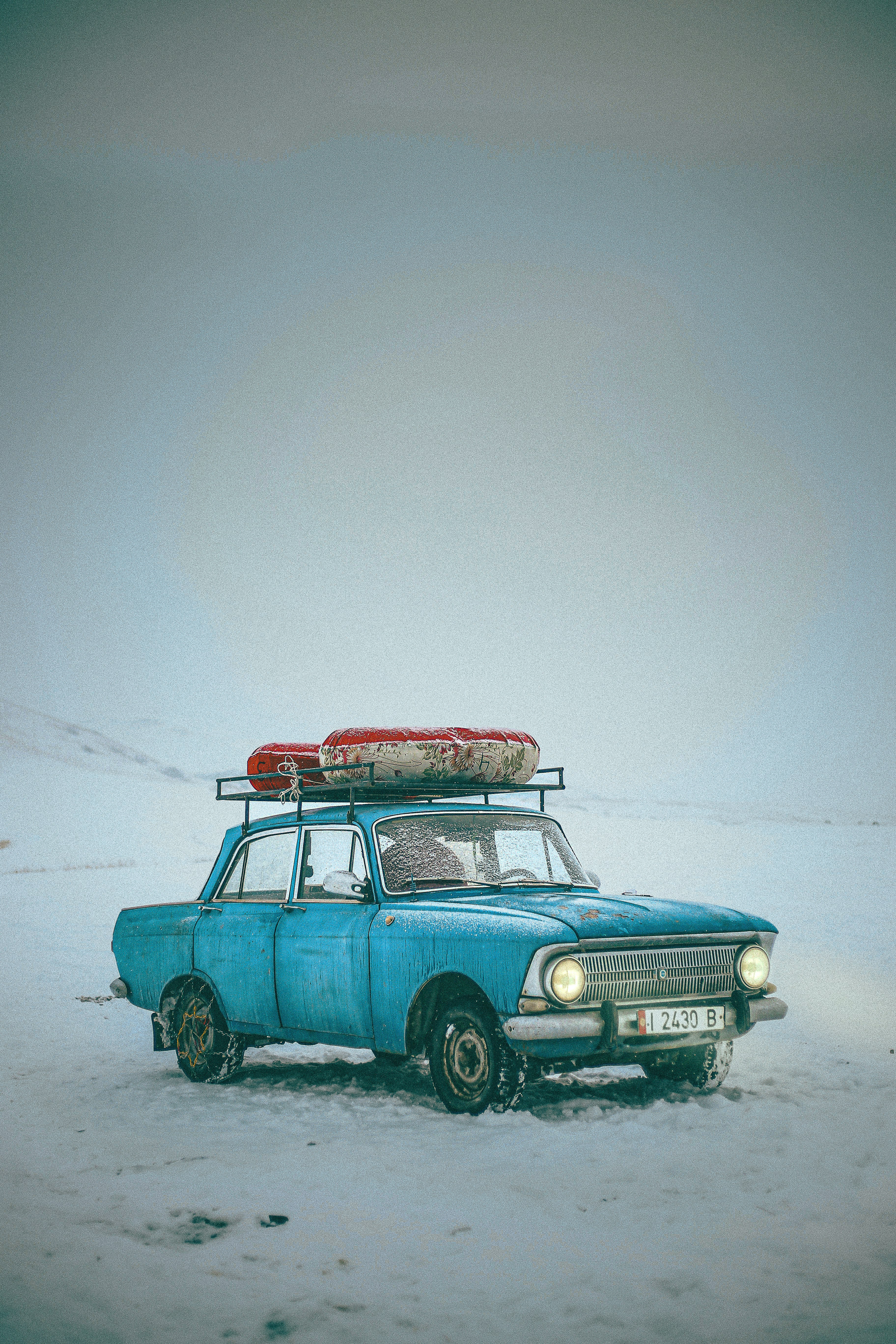 Ein blaues Auto mit einem Surfbrett darauf
