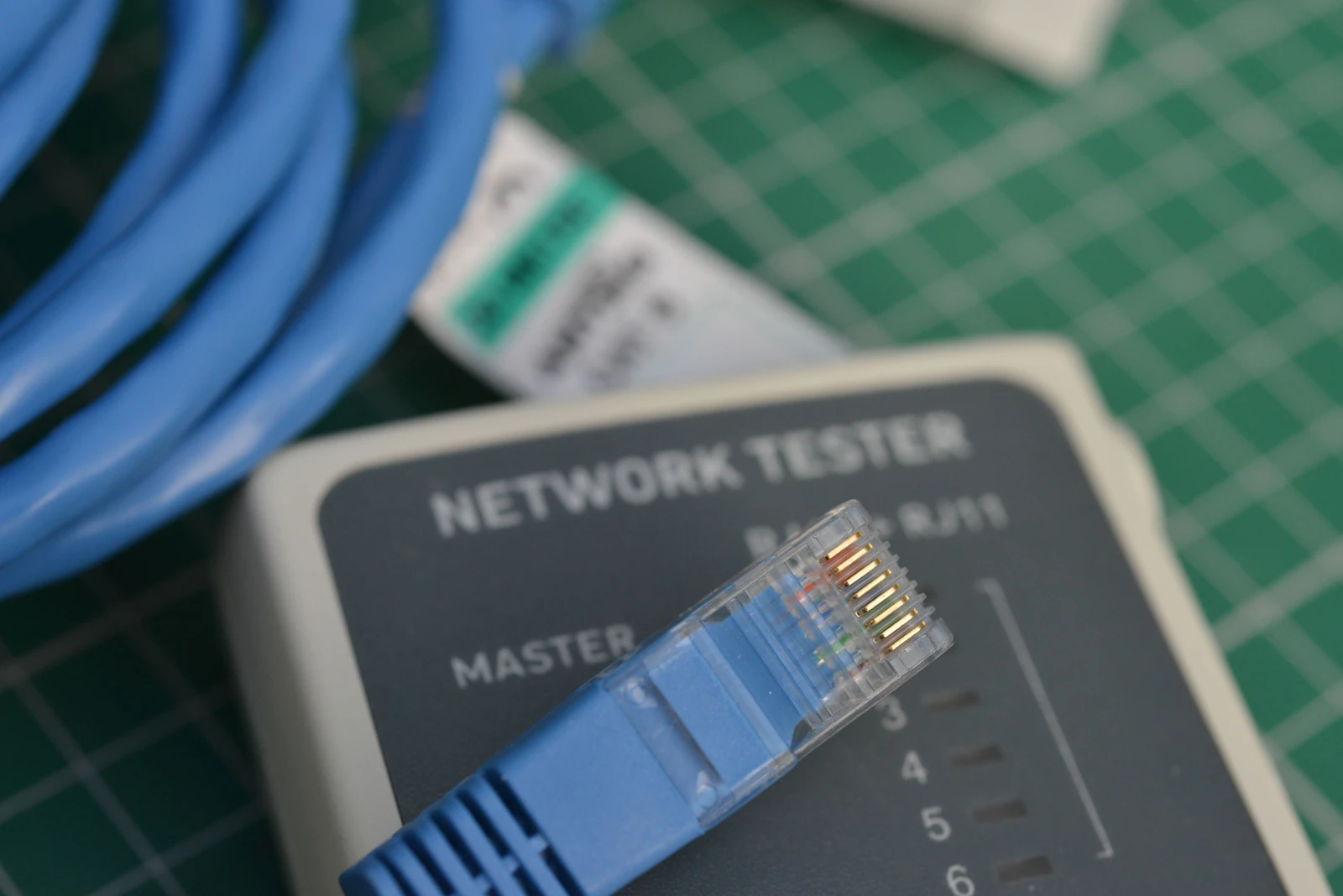 Primer plano de un cable de red conectado a un comprobador, simbolizando la administración de infraestructura